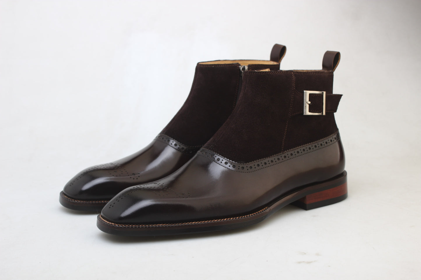 A pair of Men’s Brogue Boots with a combination of suede and polished leather, featuring a zipper and buckle design, perfect for formal and business attire.