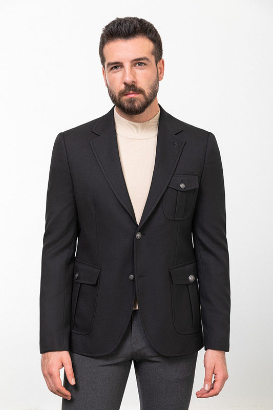 Man wearing a black blazer paired with a beige turtleneck.