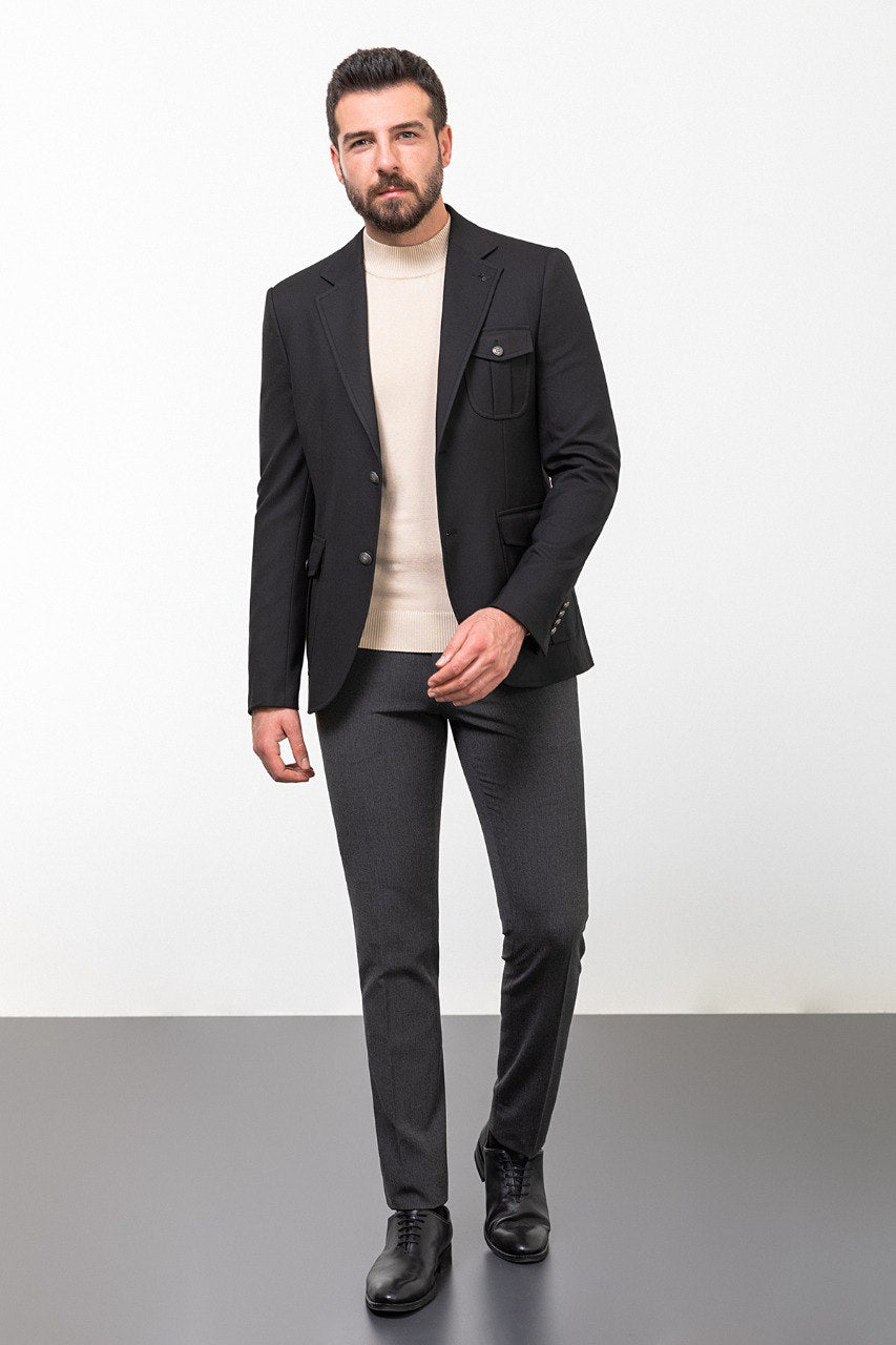 Man wearing a black blazer paired with a beige turtleneck.