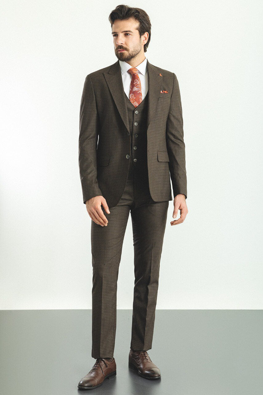 Man wearing a brown checkered 3-piece suit with a red tie and brown shoes.