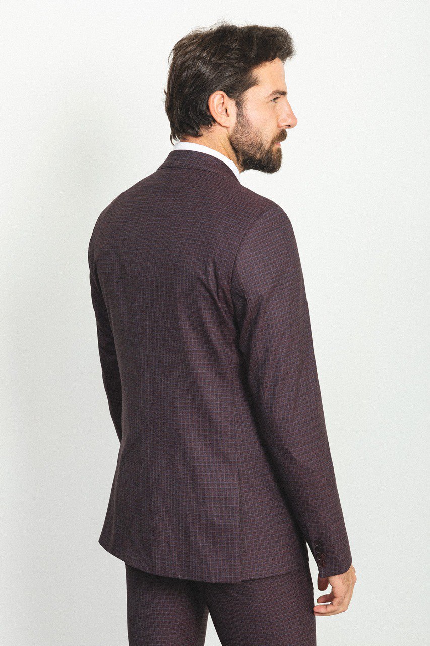 Man in a checkered burgundy 3-piece suit with a white shirt and tie.