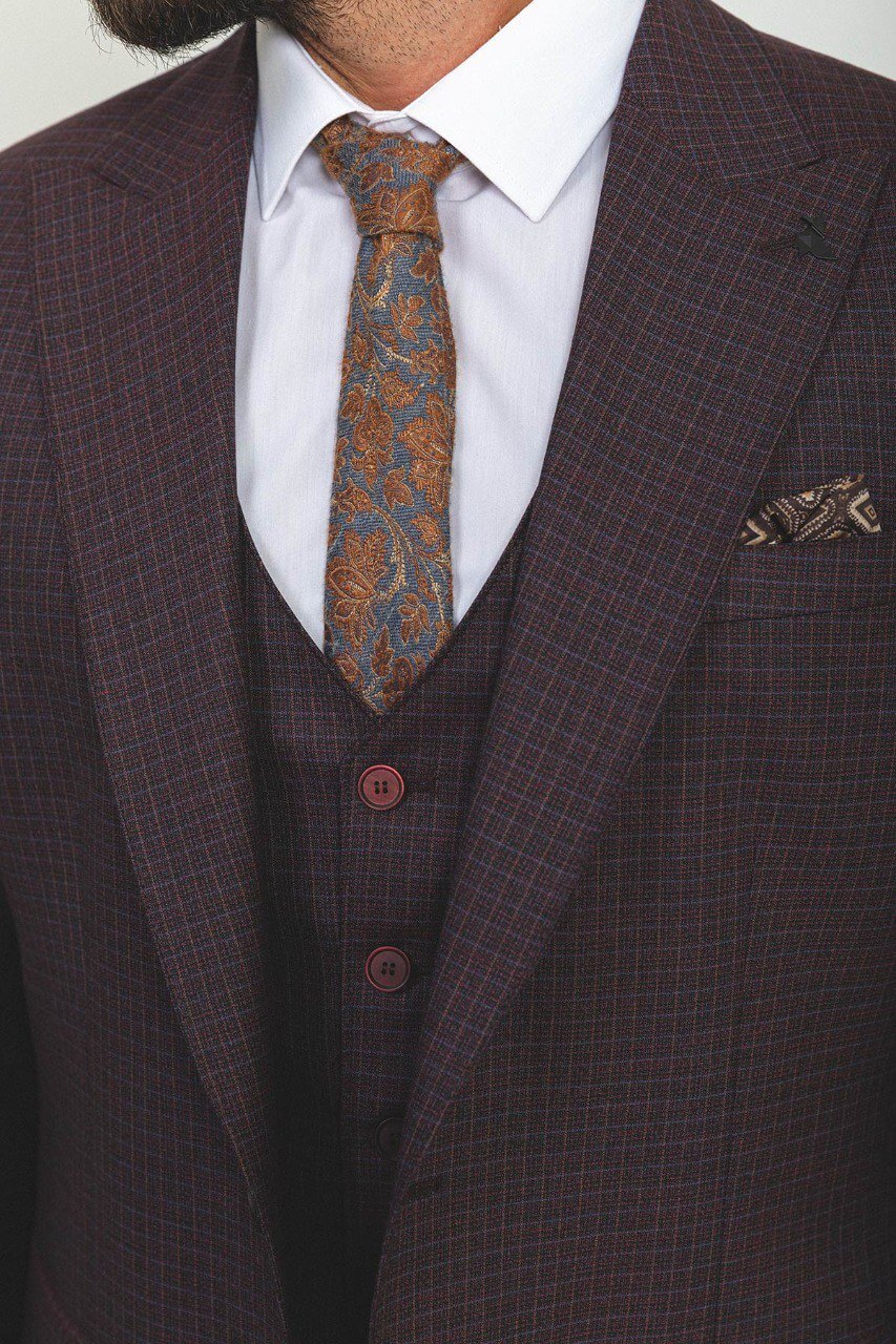 Man in a checkered burgundy 3-piece suit with a white shirt and tie.