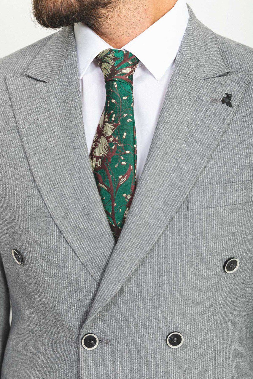 Man in double-breasted gray suit with a green patterned tie.