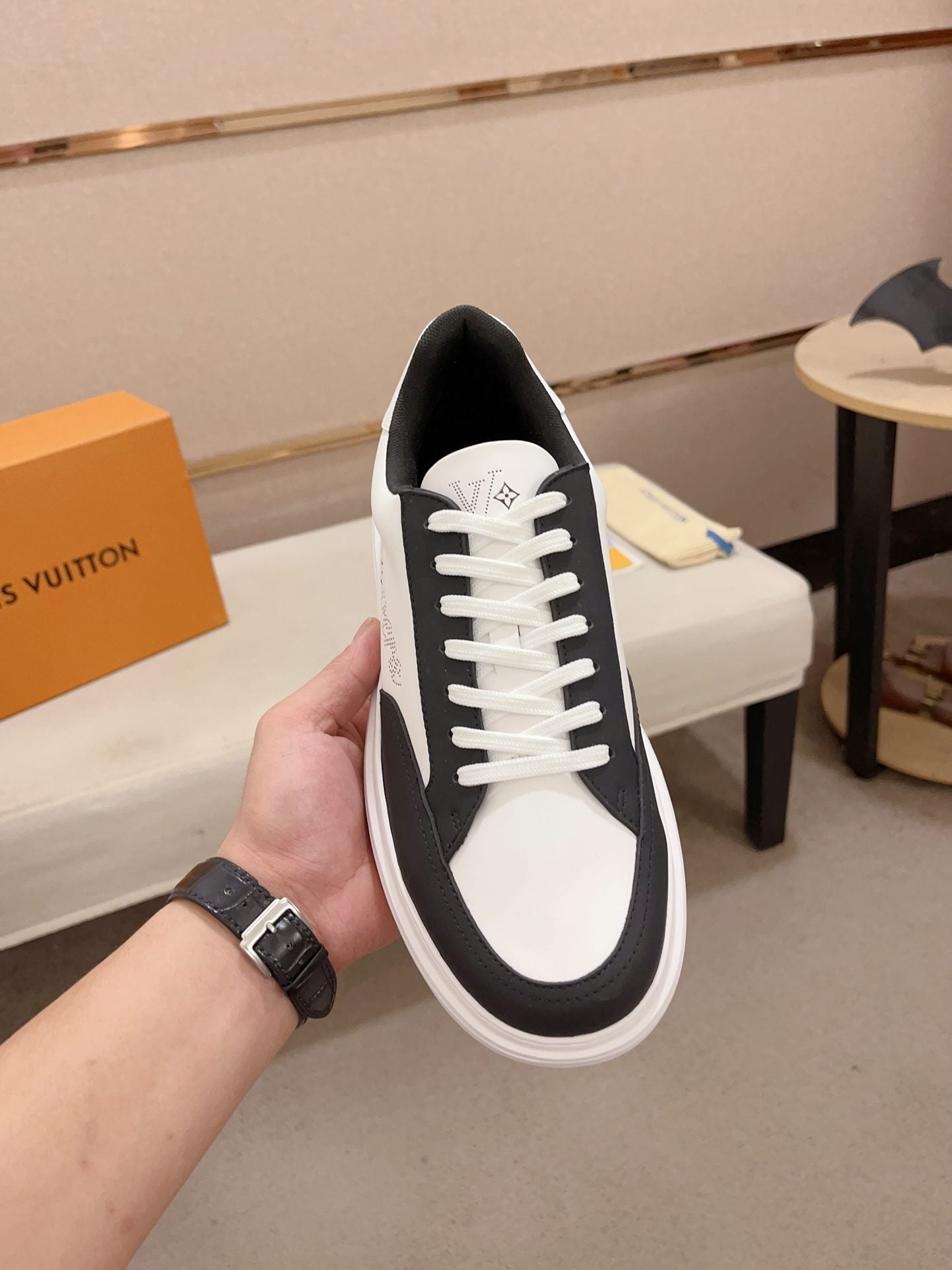 Louis Vuitton black and white contrast low-top sneakers upright top view held in hand