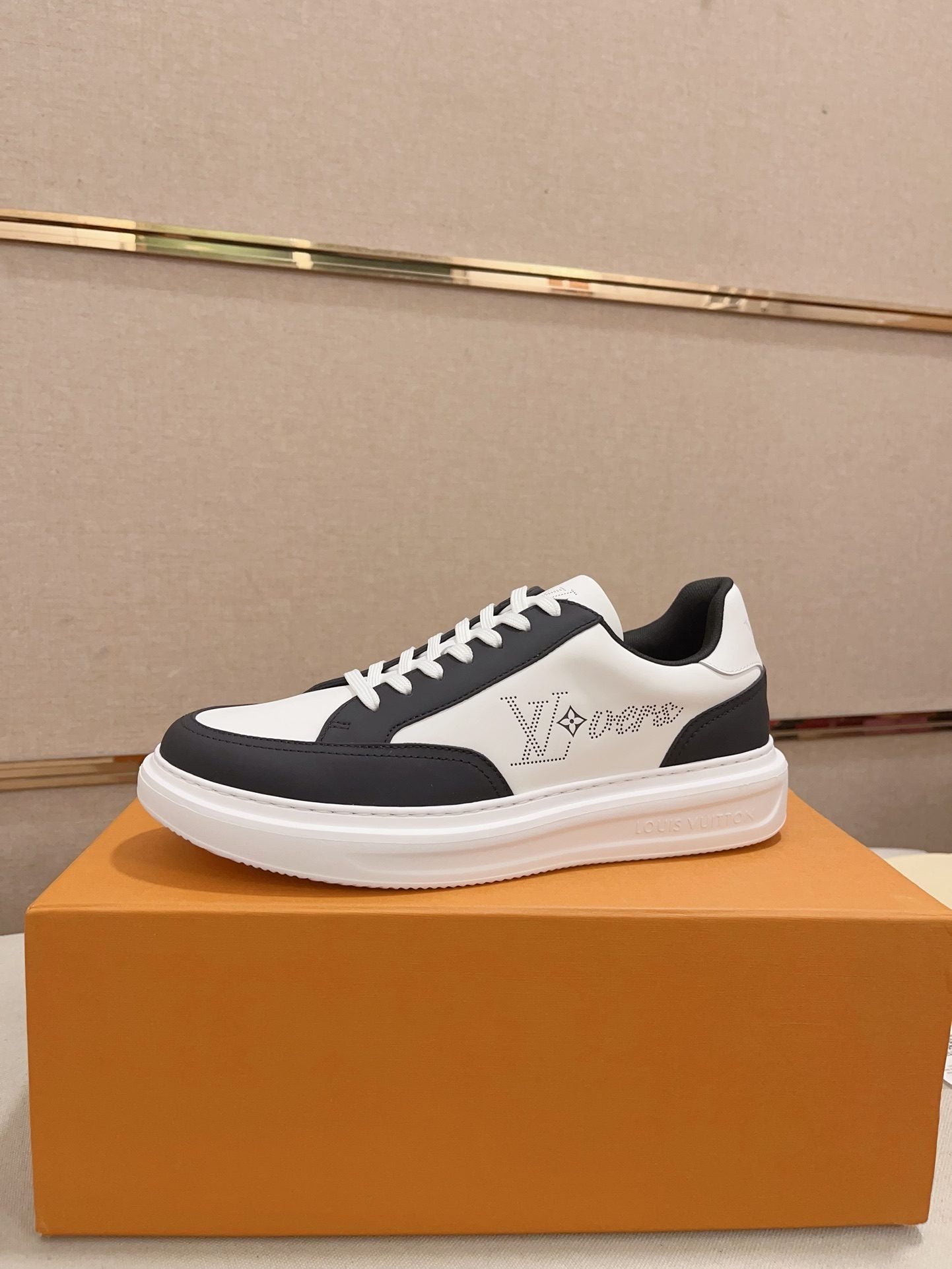 Louis Vuitton black and white contrast low-top sneakers side profile on orange box