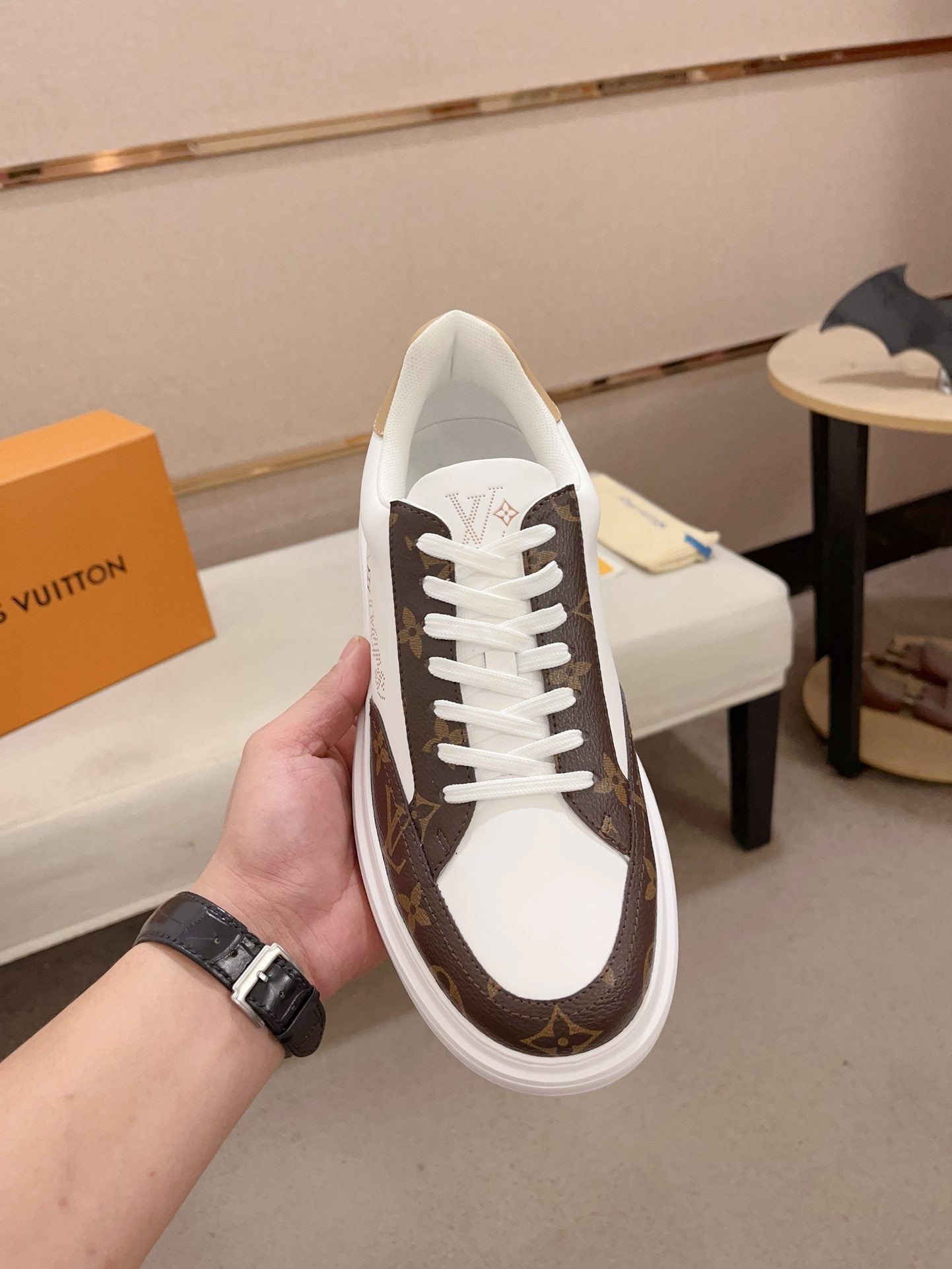 Louis Vuitton brown and white Monogram low-top sneakers top view held upright