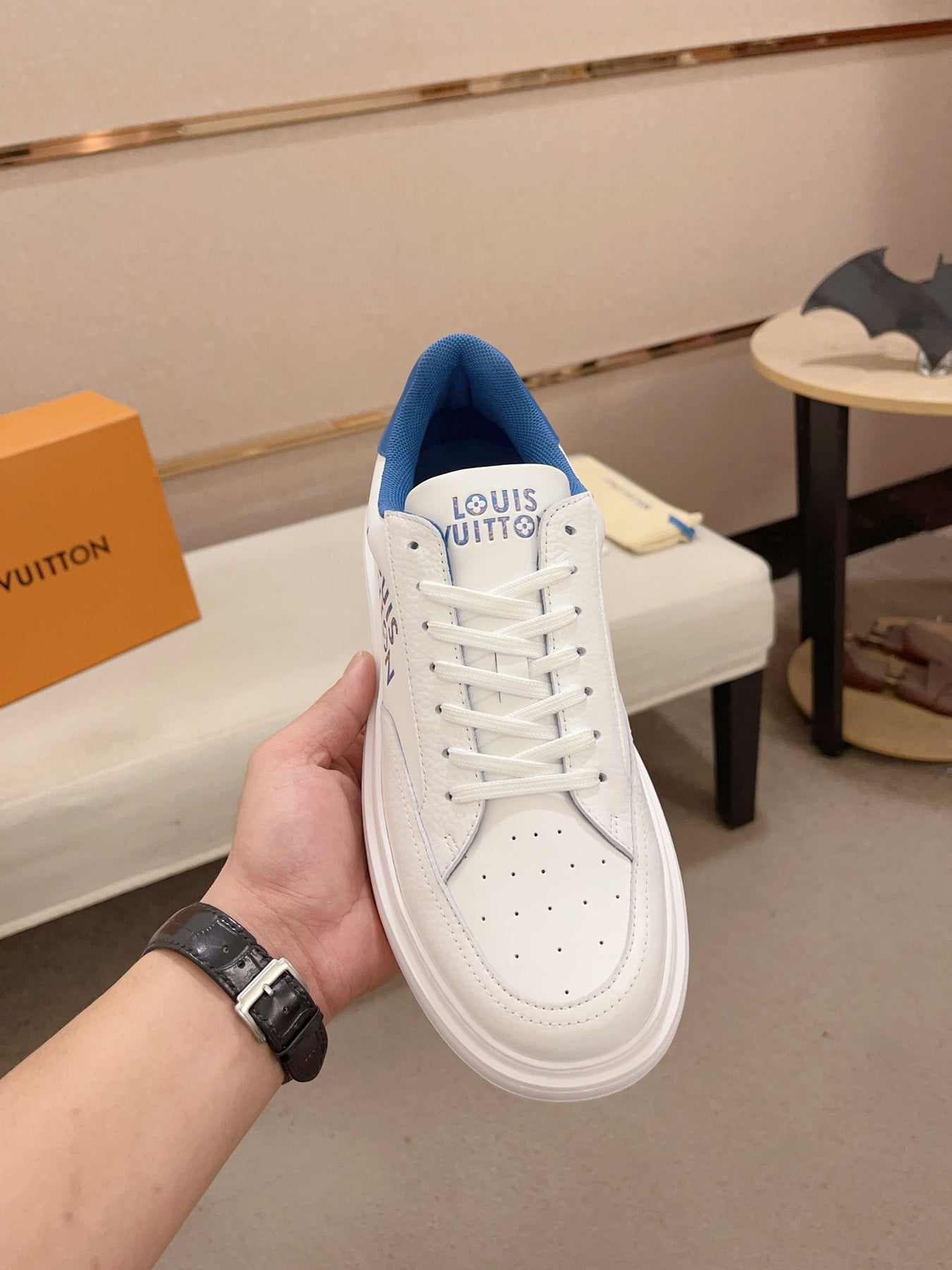 Louis Vuitton white and blue logo low-top sneakers top view held upright