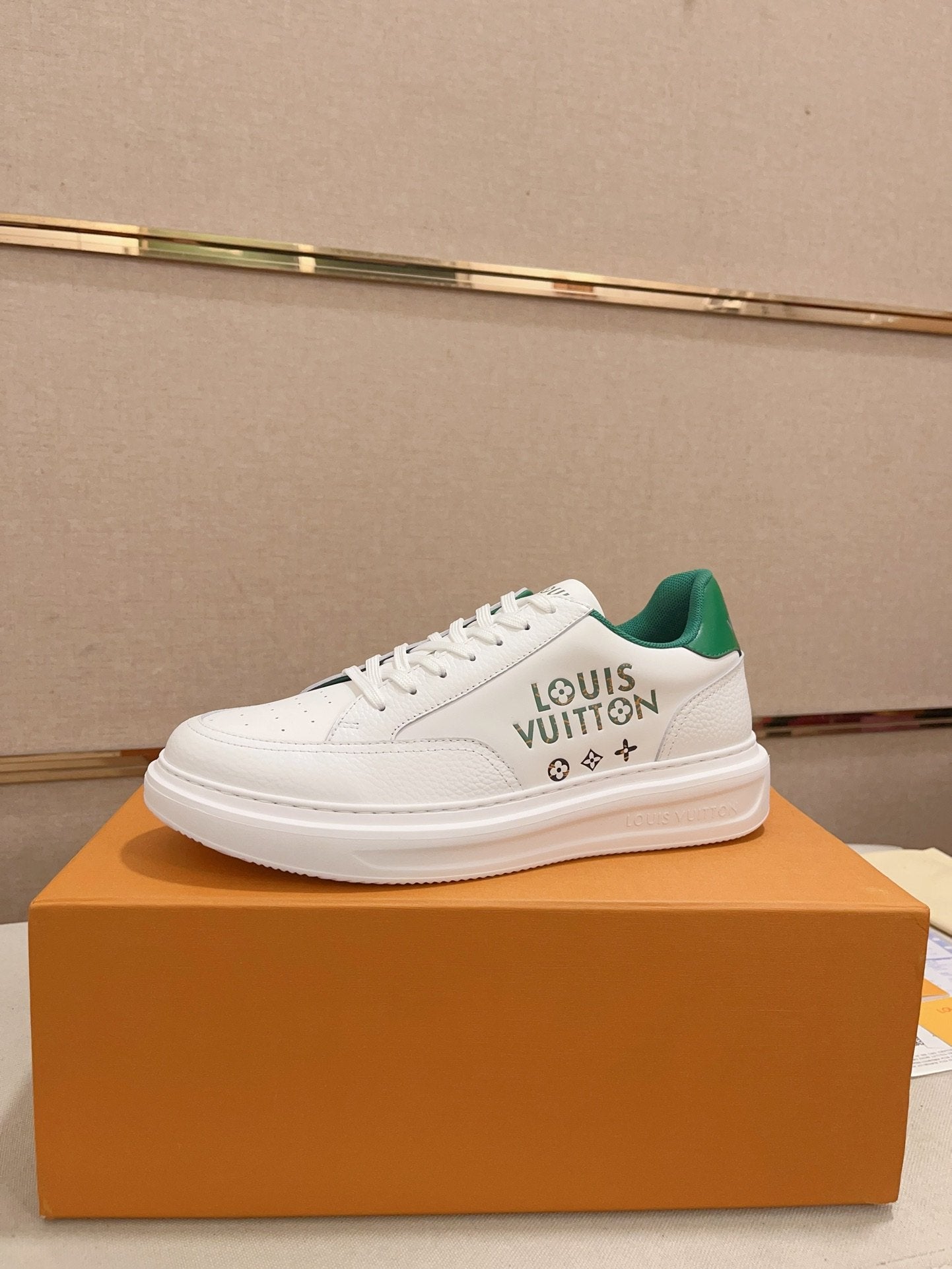 Louis Vuitton white and green logo low-top sneakers side profile on orange box