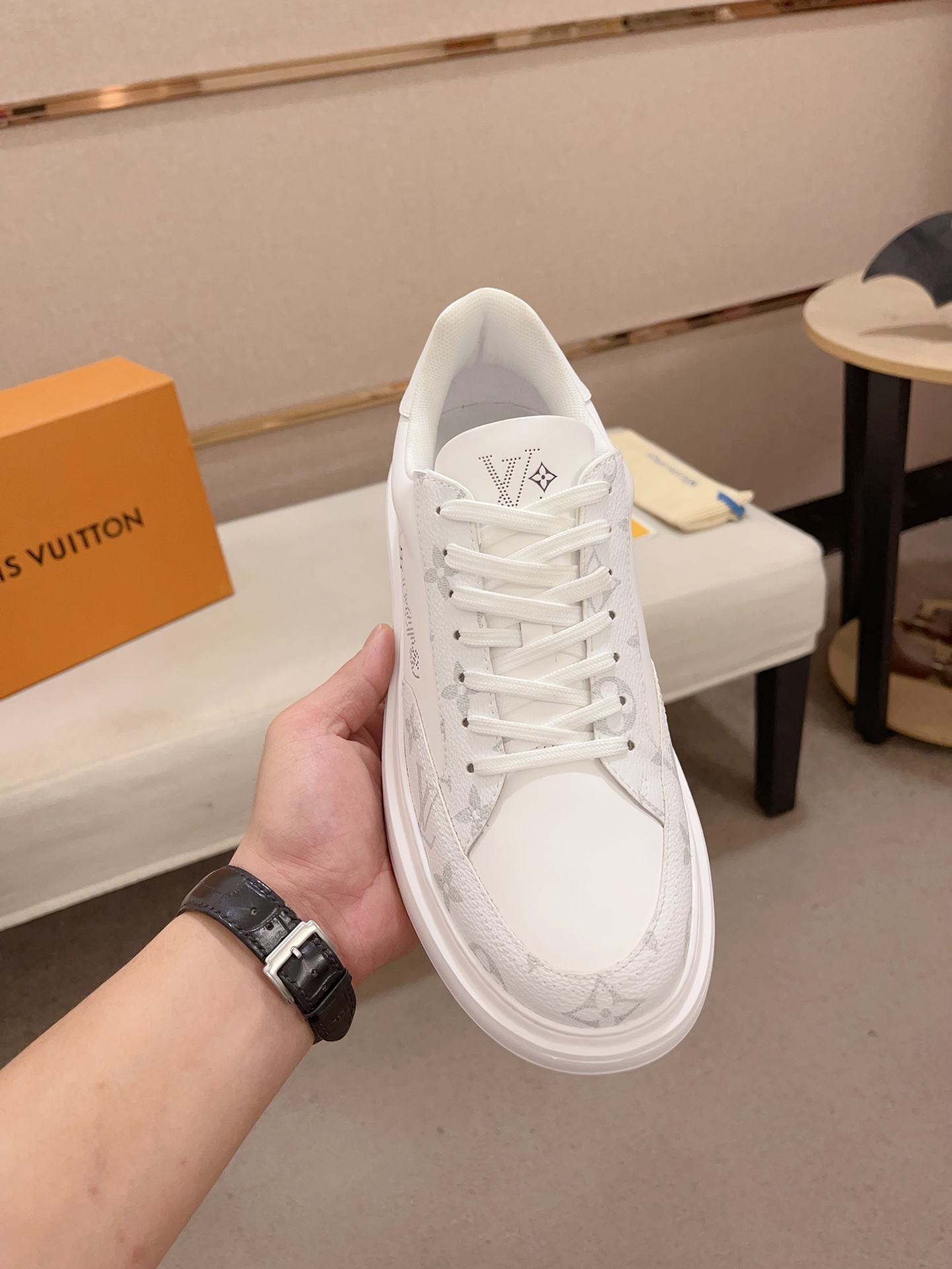 Louis Vuitton white and grey Monogram low-top sneakers top view held upright
