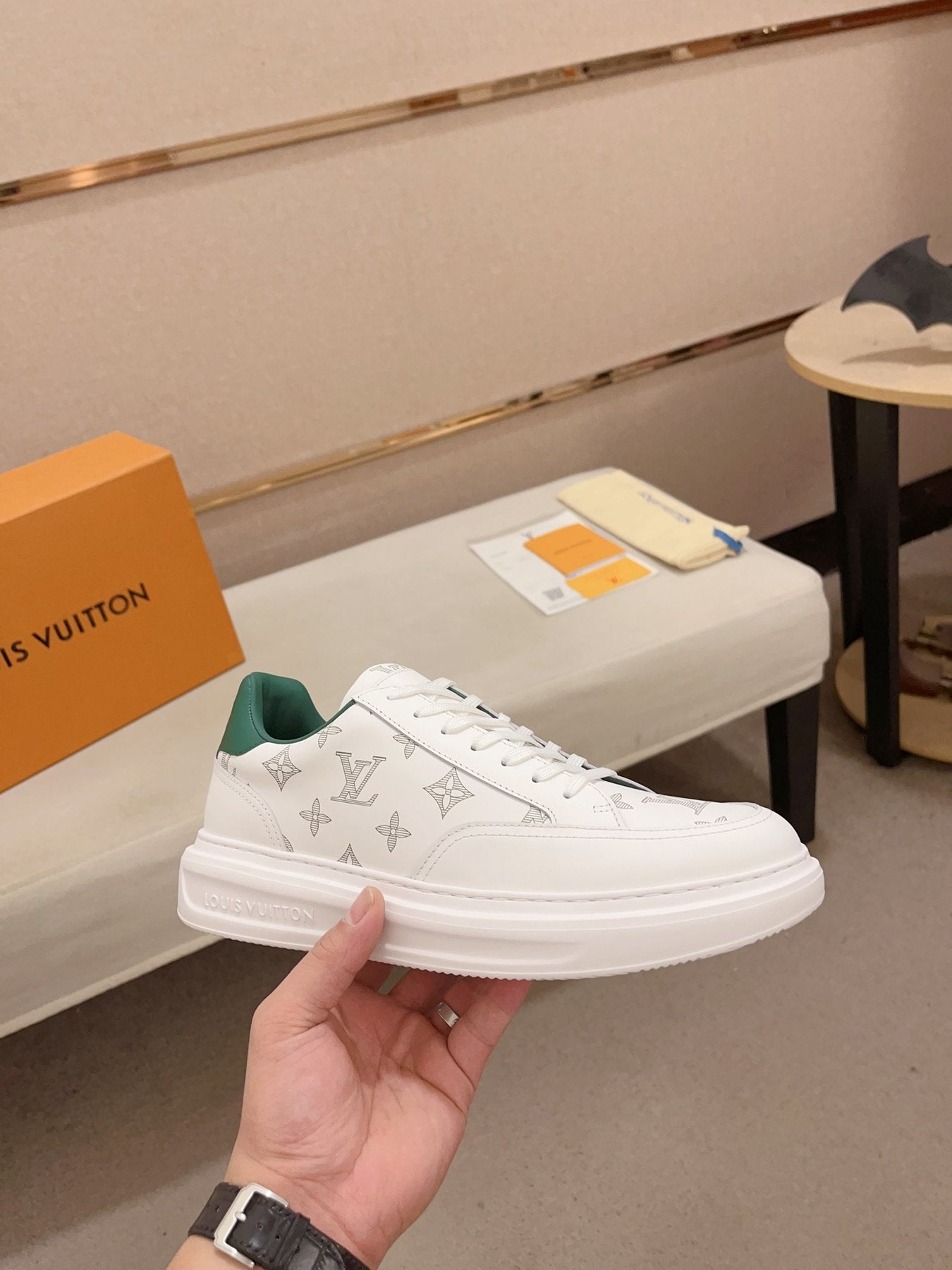 Louis Vuitton white monogram green heel low-top sneakers side profile held in hand