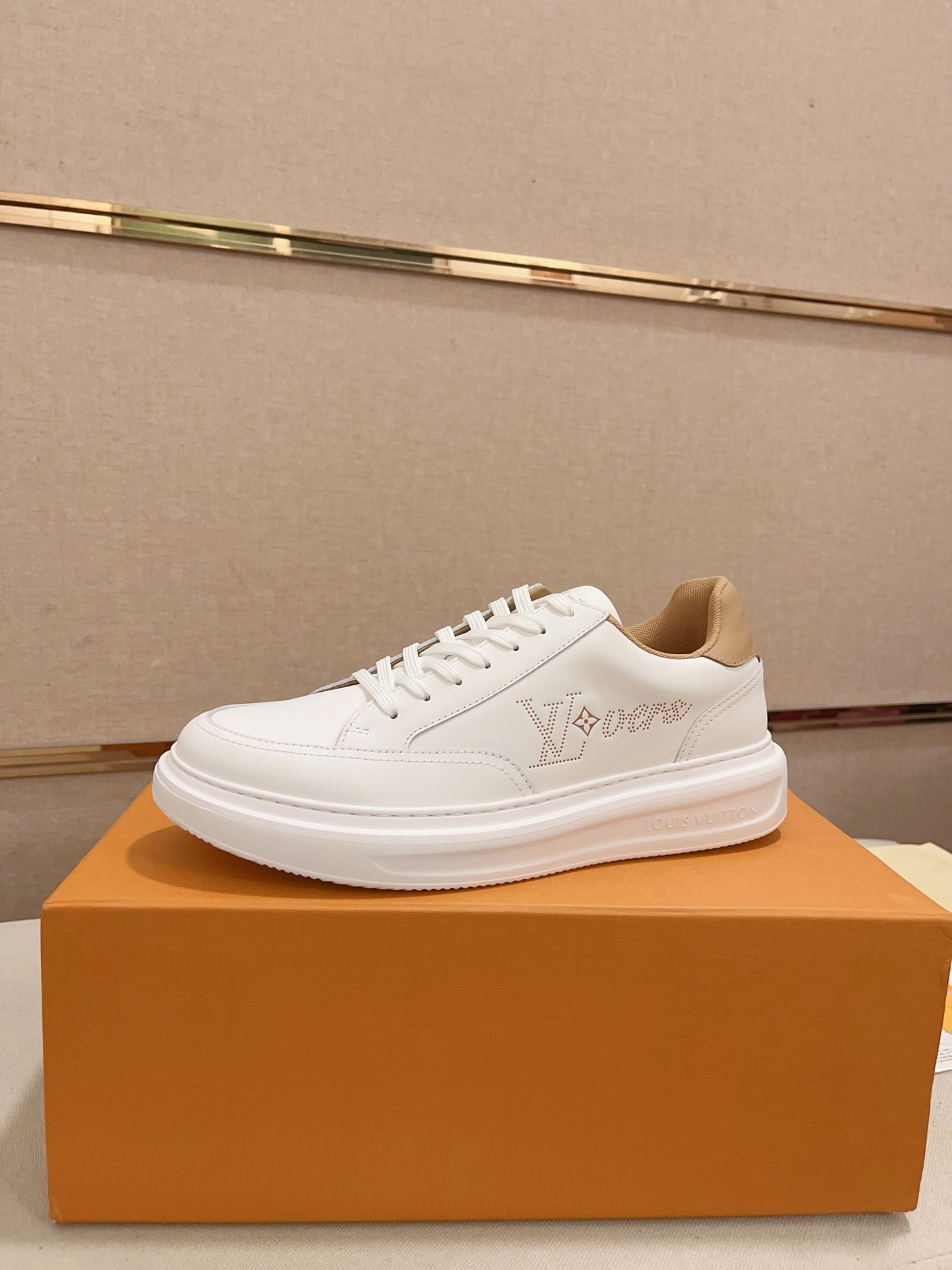 Louis Vuitton white and tan perforated LV low-top sneakers side profile on orange box
