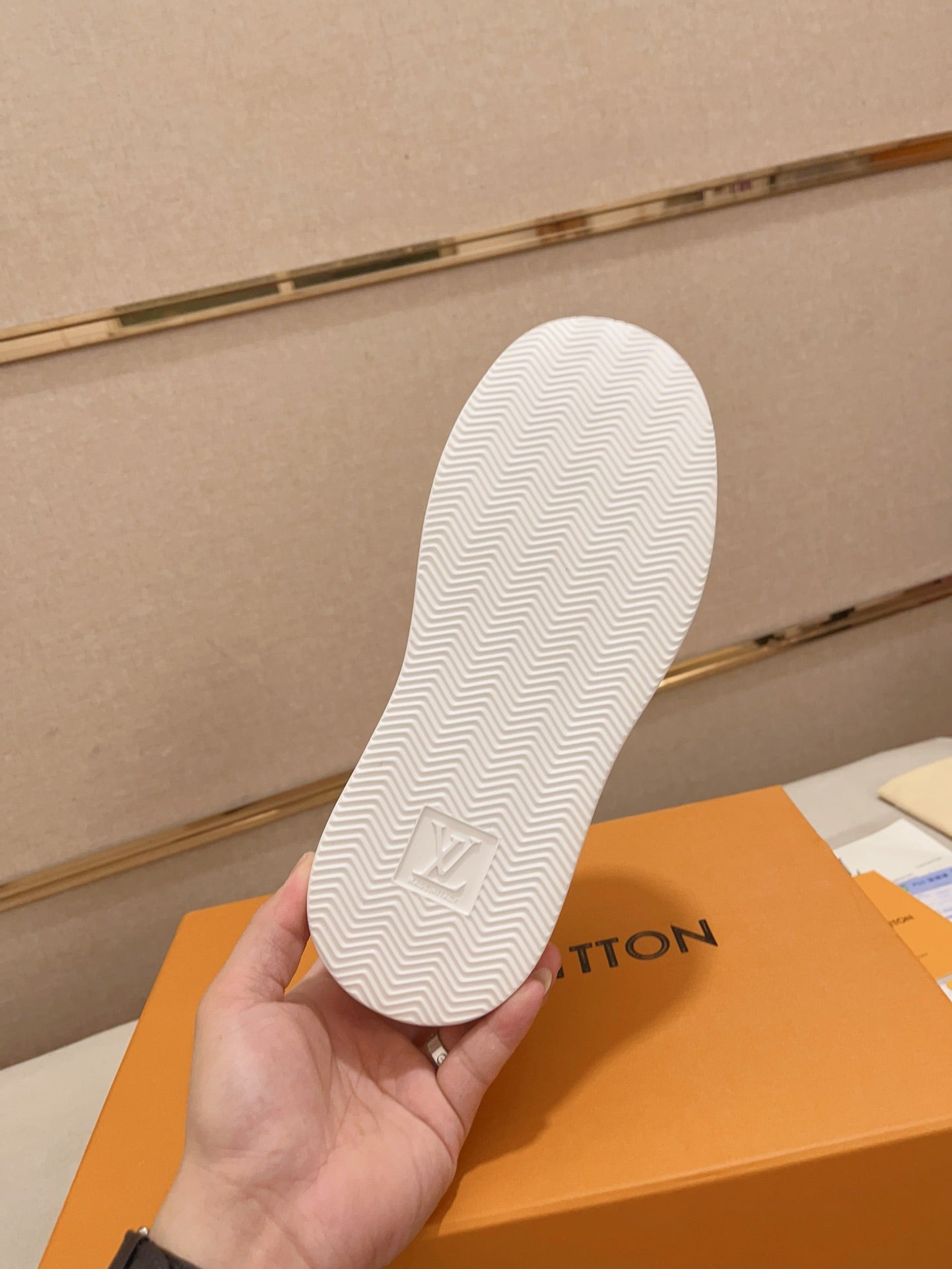 Louis Vuitton white and tan perforated LV low-top sneakers outsole tread view