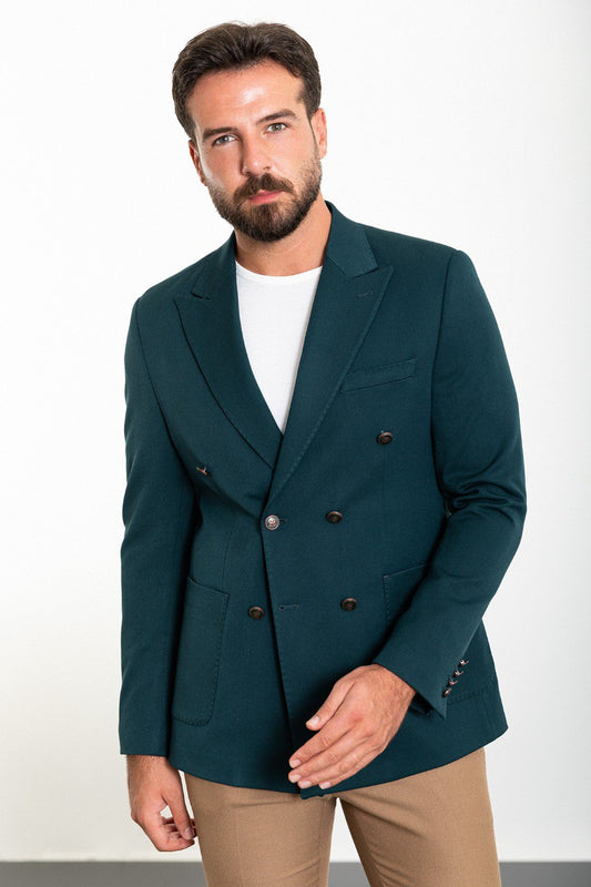 Man wearing a teal double-breasted blazer paired with beige trousers.