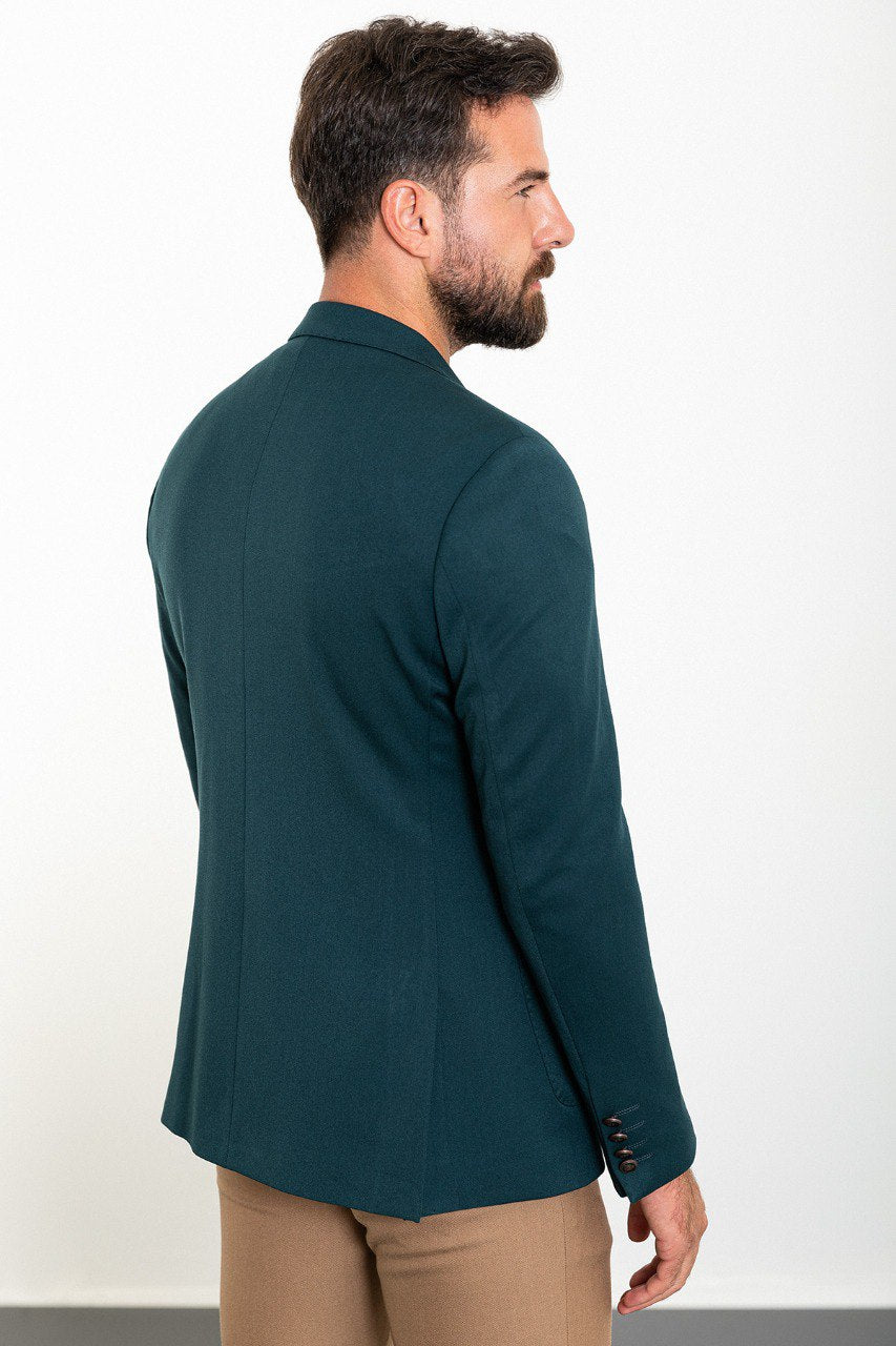 Man wearing a teal double-breasted blazer paired with beige trousers.