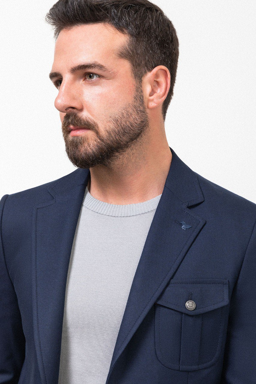 Man wearing a navy blue blazer with a light grey shirt, perfect for a smart-casual or business outfit, showcasing tailored elegance and modern style.