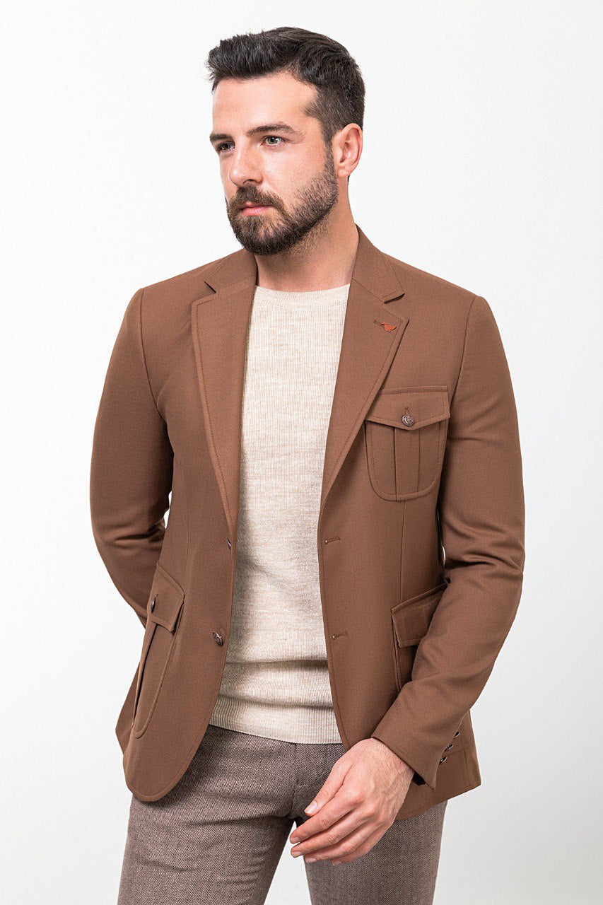 Man wearing a brown tailored blazer paired with a beige sweater and brown trousers, showcasing a smart-casual fall outfit.