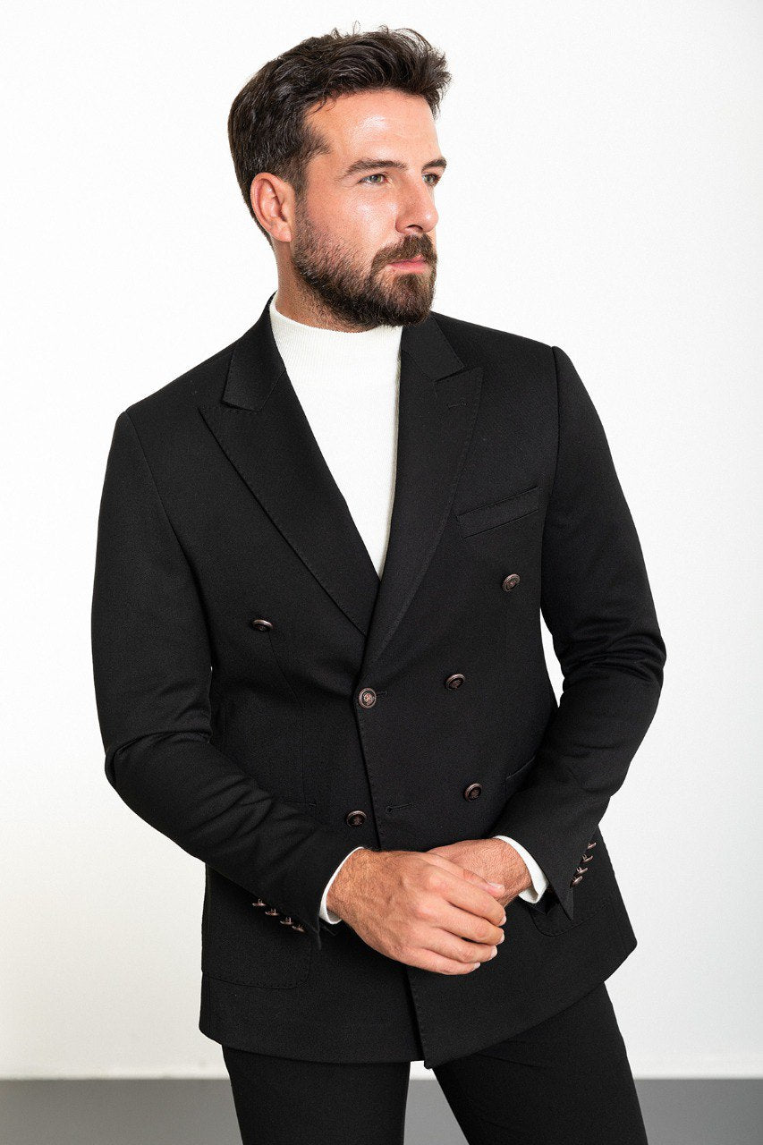 Man wearing a black double-breasted blazer with a white turtleneck, showcasing a modern and sophisticated look for formal or smart-casual occasions.