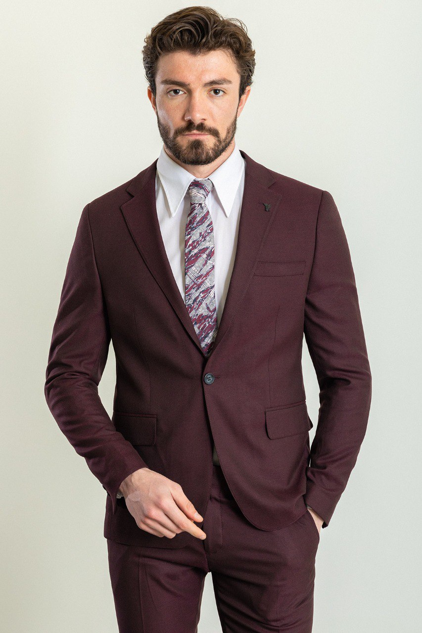 Man wearing a Bordeaux Regal Suit with a sharp pointed collar, flap pockets, and a slim fit, perfect for weddings and business events.