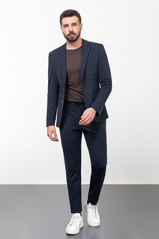 Man wearing a navy blue leisure suit with white sneakers.