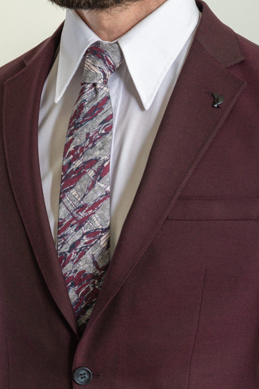 Man wearing a Bordeaux Regal Suit with a sharp pointed collar, flap pockets, and a slim fit, perfect for weddings and business events.