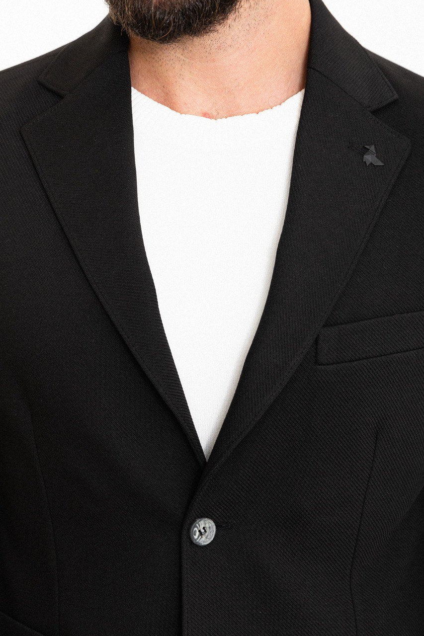 Man wearing a black suit with a white shirt.