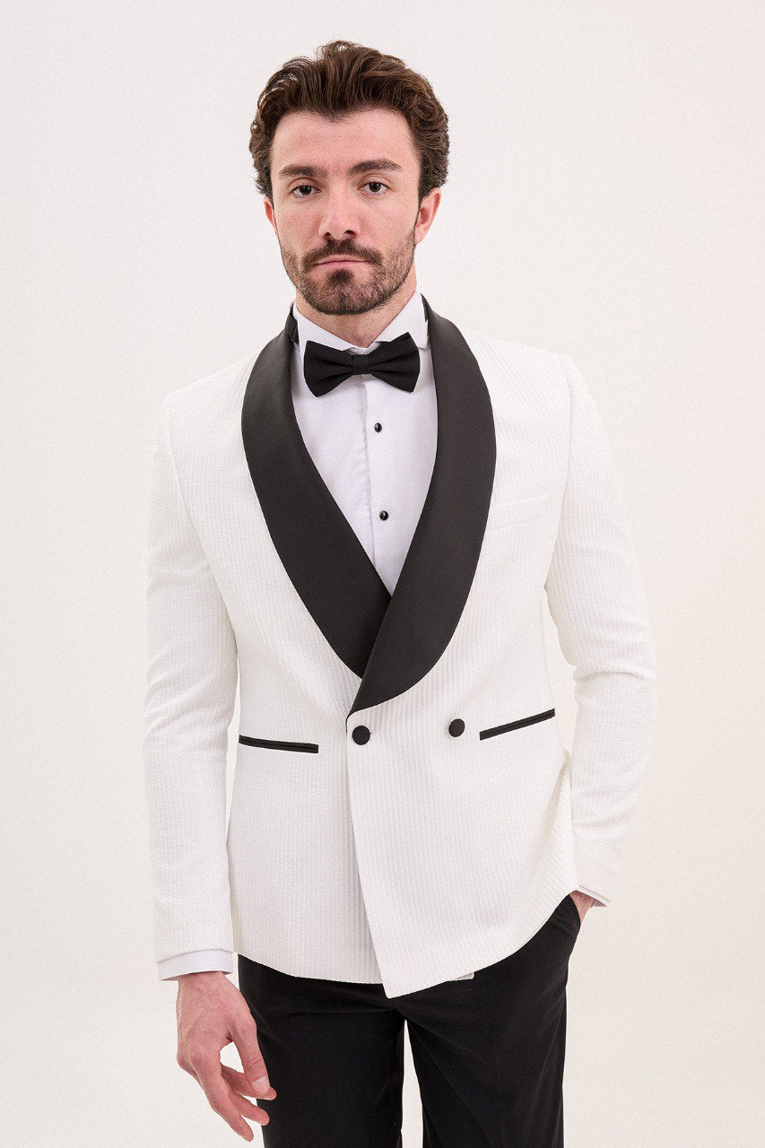 Man wearing a white tuxedo jacket with black shawl lapel and black pants.