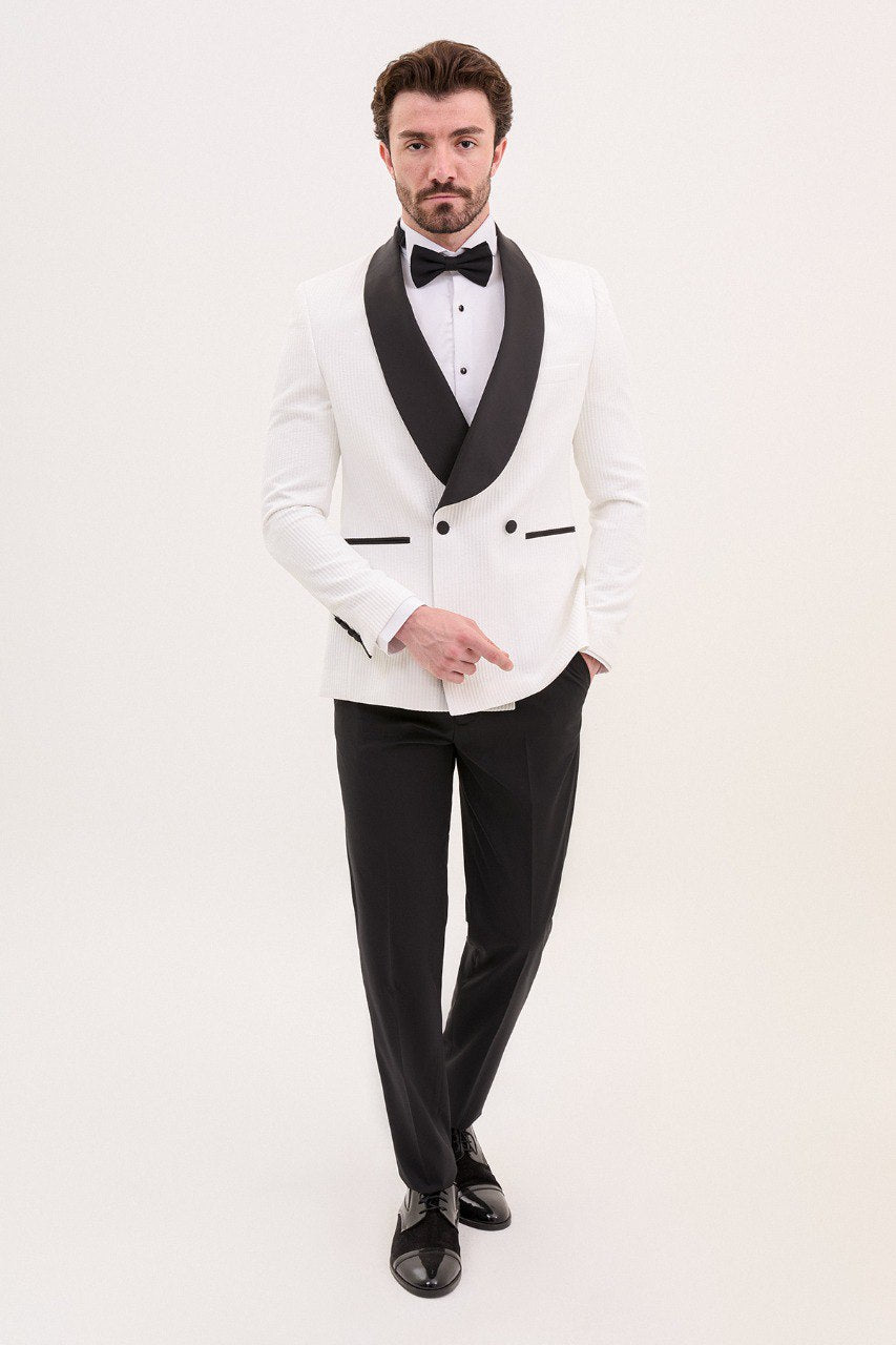 Man wearing a white tuxedo jacket with black shawl lapel and black pants.