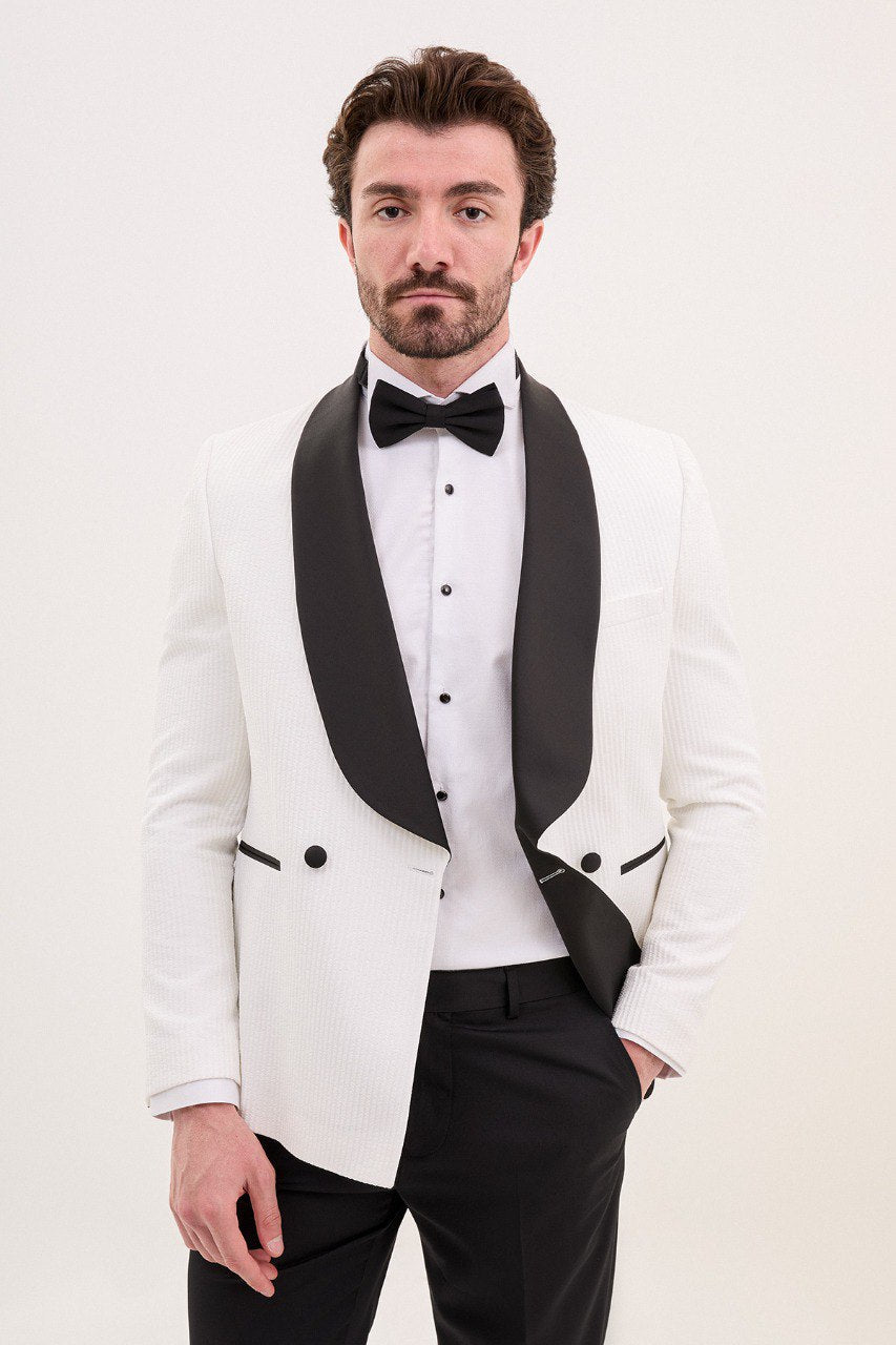 Man wearing a white tuxedo jacket with black shawl lapel and black pants.