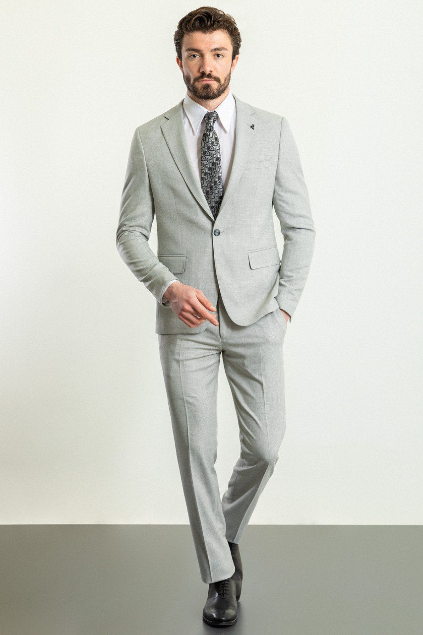 Man wearing a Silver Slate Suit with a sharp pointed collar, flap pockets, and a slim fit, perfect for weddings and business events.