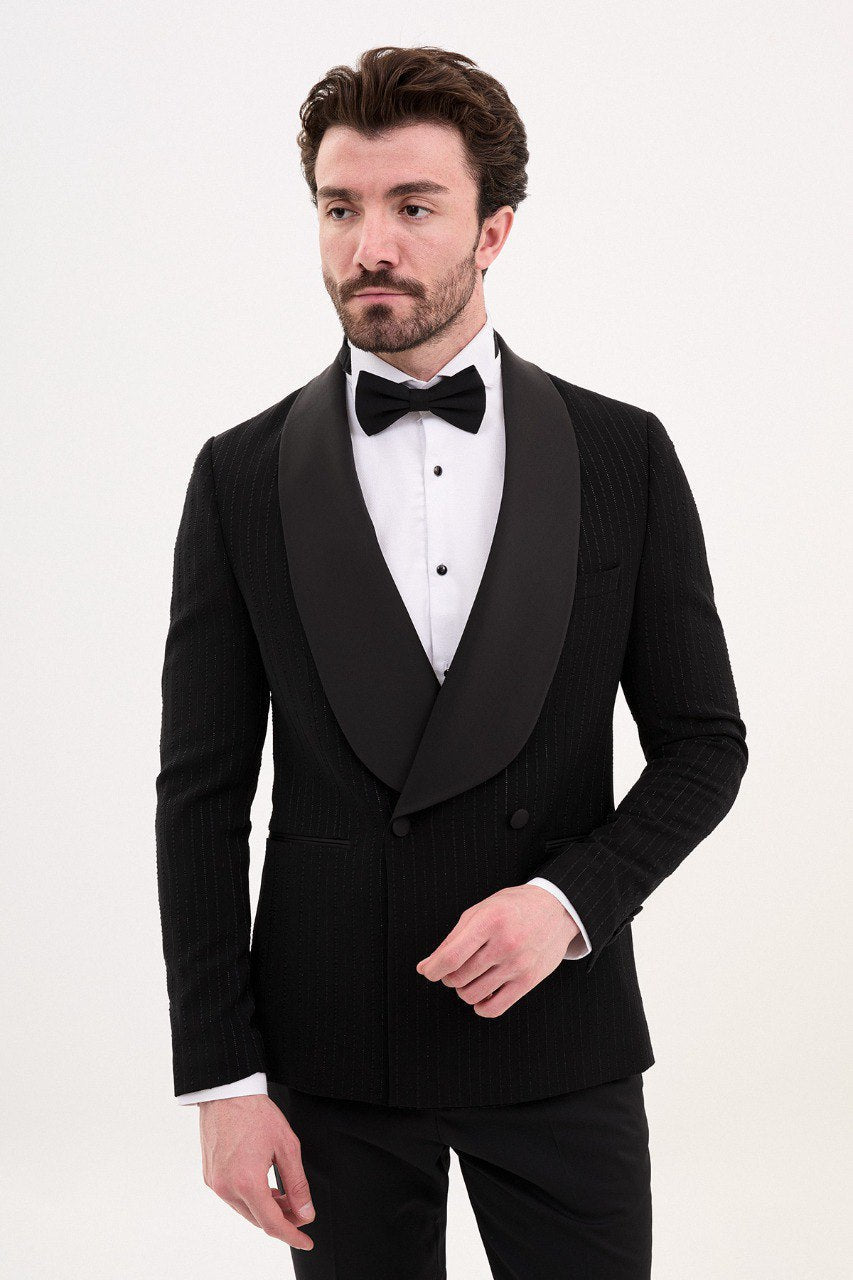 Man wearing a black double-breasted tuxedo with a shawl collar and bow tie.