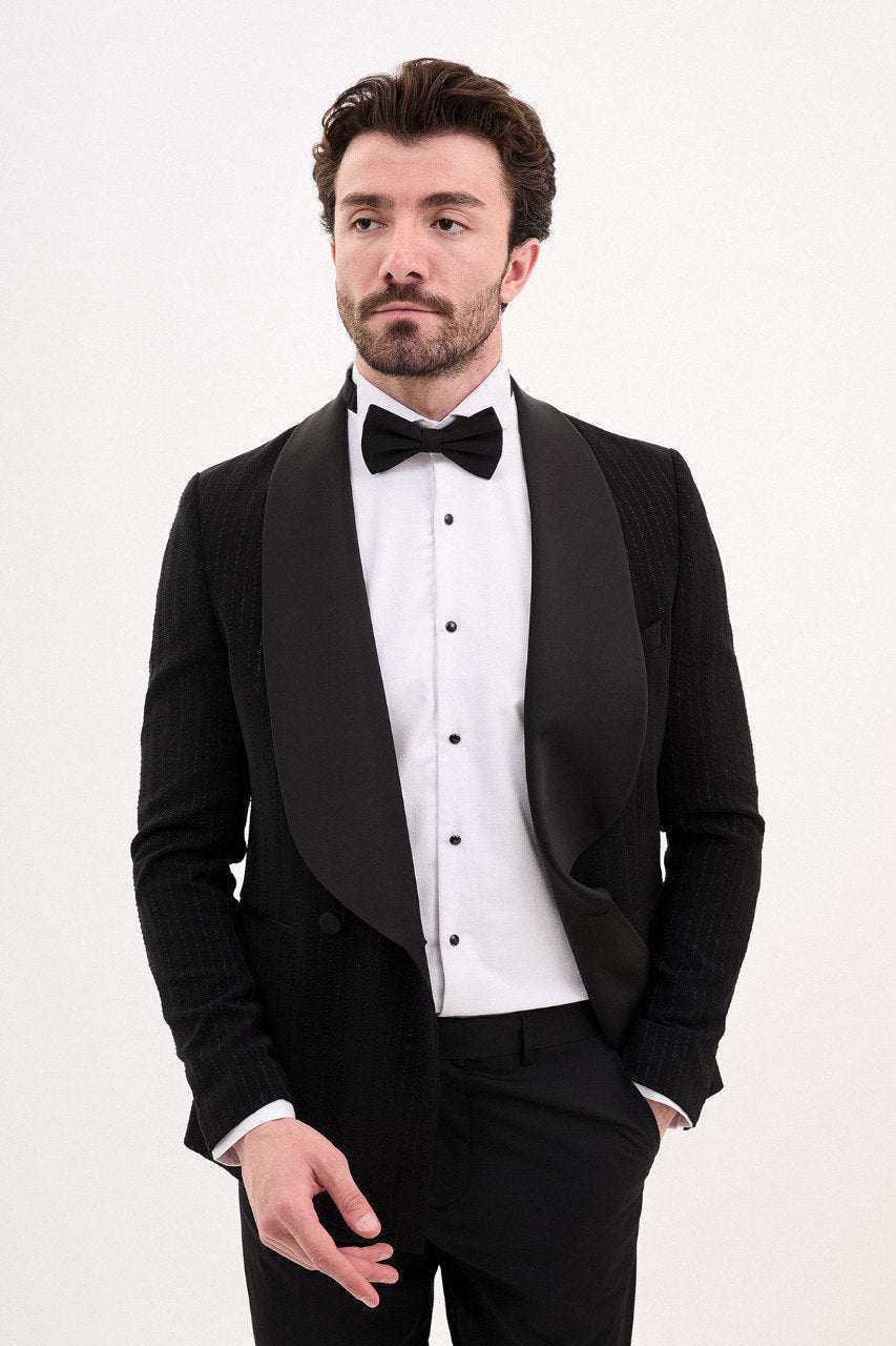 Man wearing a black double-breasted tuxedo with a shawl collar and bow tie.