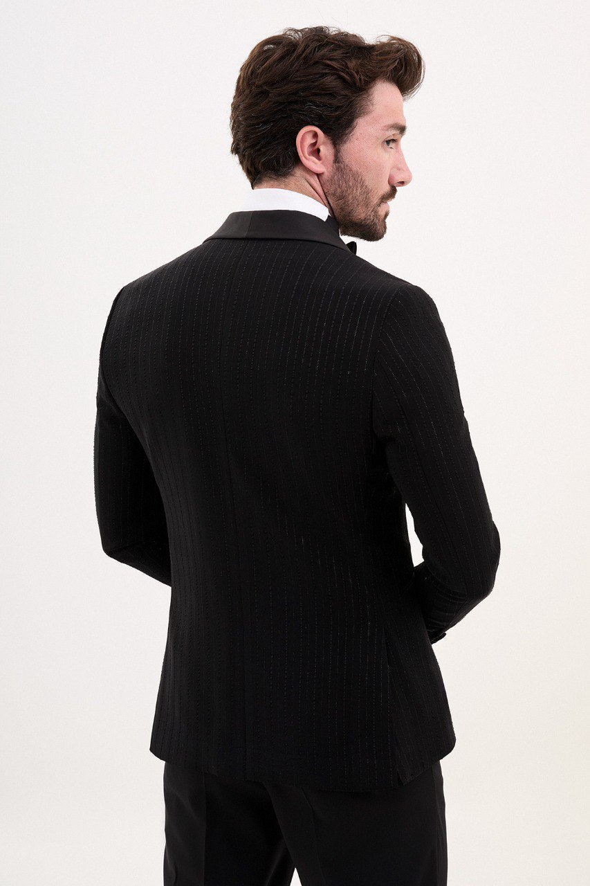 Man wearing a black double-breasted tuxedo with a shawl collar and bow tie.