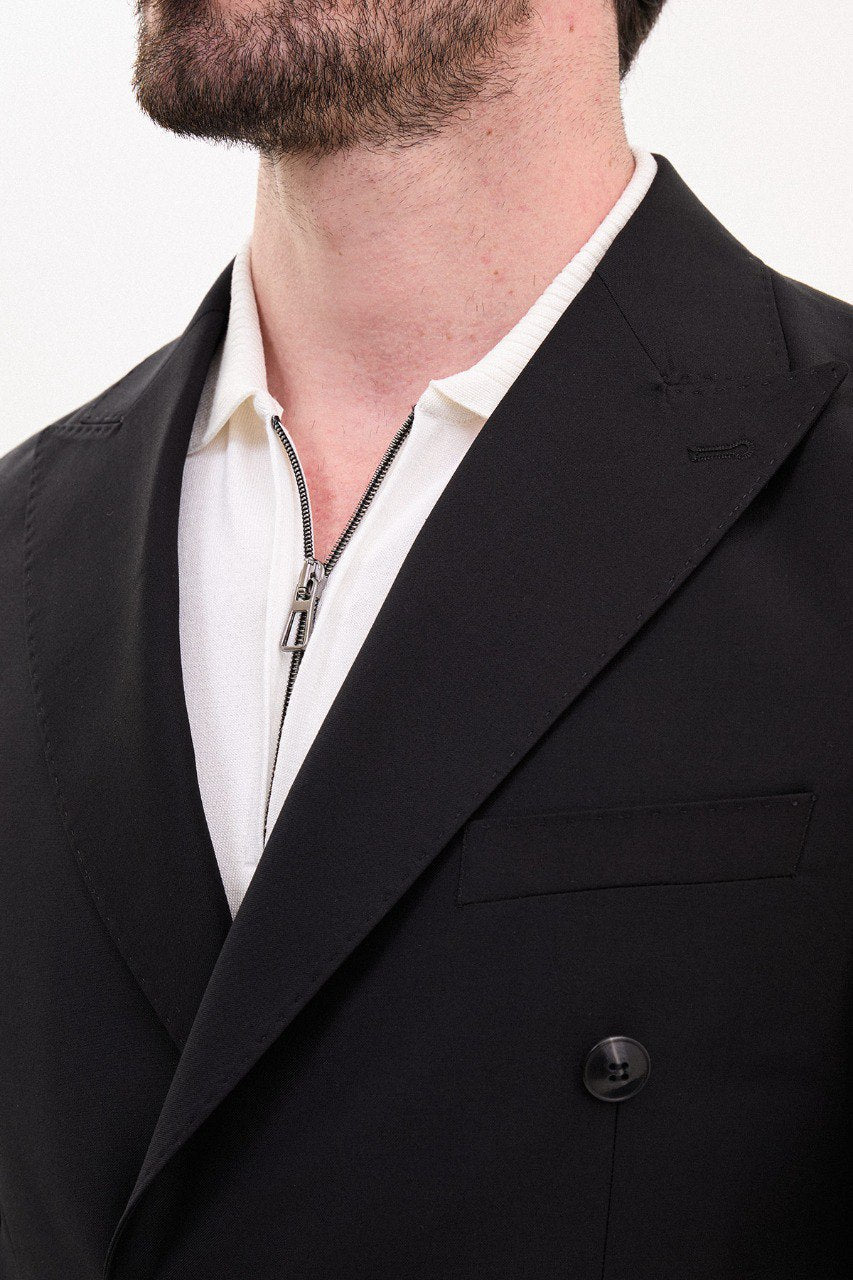 Man wearing a black double-breasted suit.