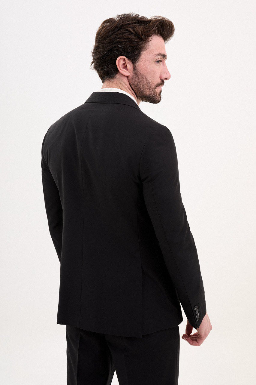 Man wearing a black double-breasted suit.