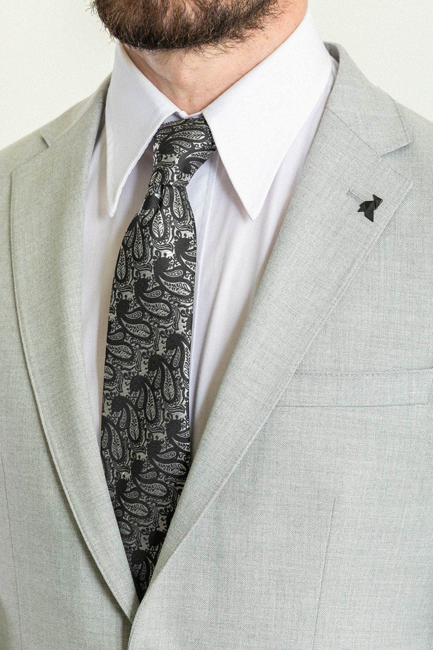 Man wearing a Silver Slate Suit with a sharp pointed collar, flap pockets, and a slim fit, perfect for weddings and business events.