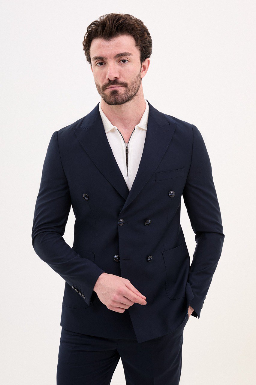 Man wearing a navy blue double-breasted suit with a polo shirt.