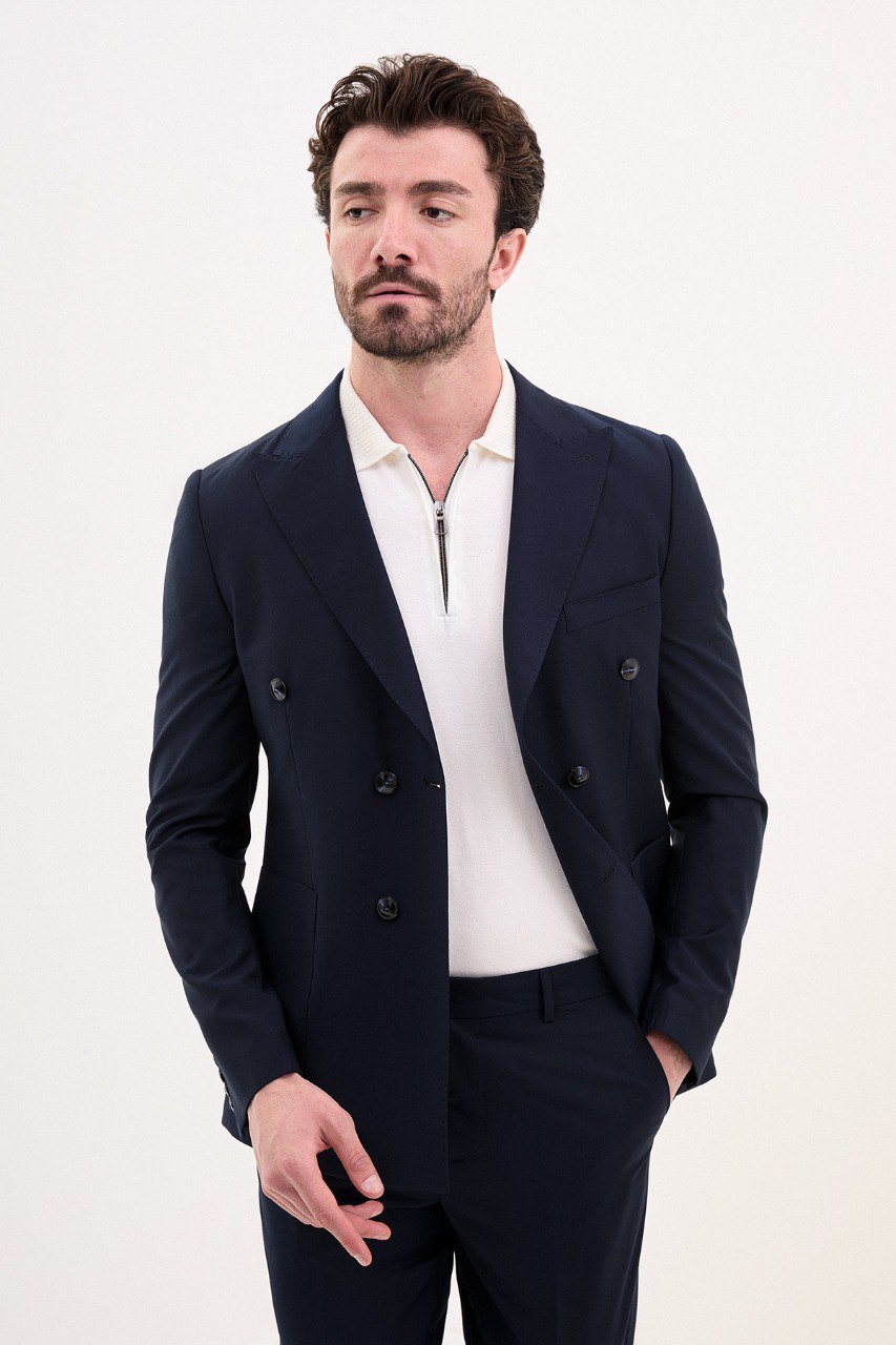 Man wearing a navy blue double-breasted suit with a polo shirt.