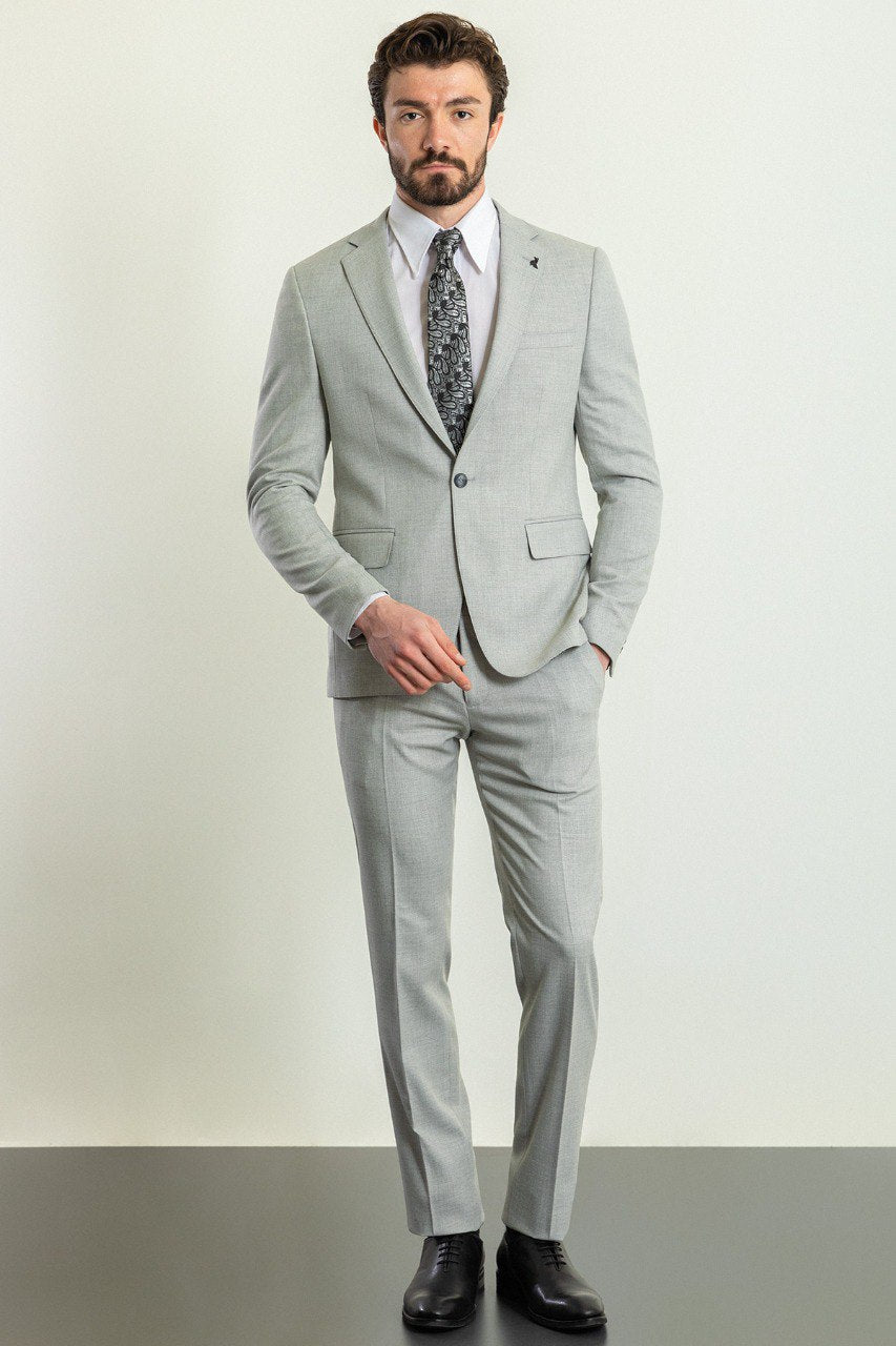 Man wearing a Silver Slate Suit with a sharp pointed collar, flap pockets, and a slim fit, perfect for weddings and business events.