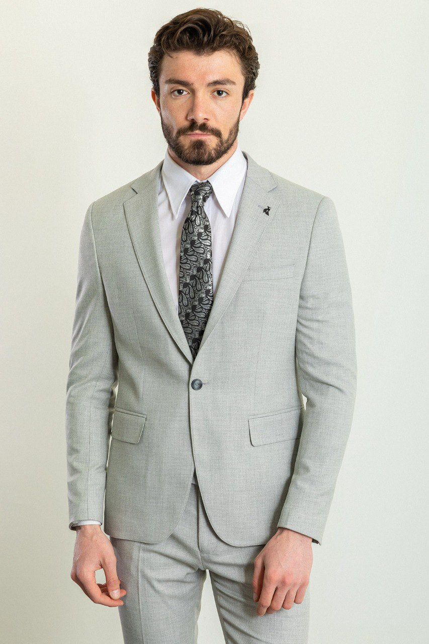 Man wearing a Silver Slate Suit with a sharp pointed collar, flap pockets, and a slim fit, perfect for weddings and business events.