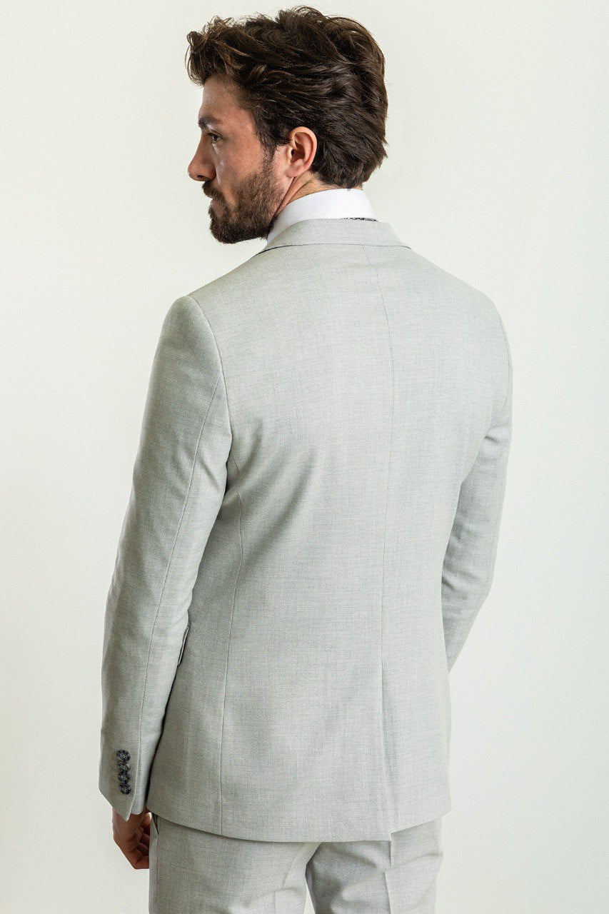 Man wearing a Silver Slate Suit with a sharp pointed collar, flap pockets, and a slim fit, perfect for weddings and business events.