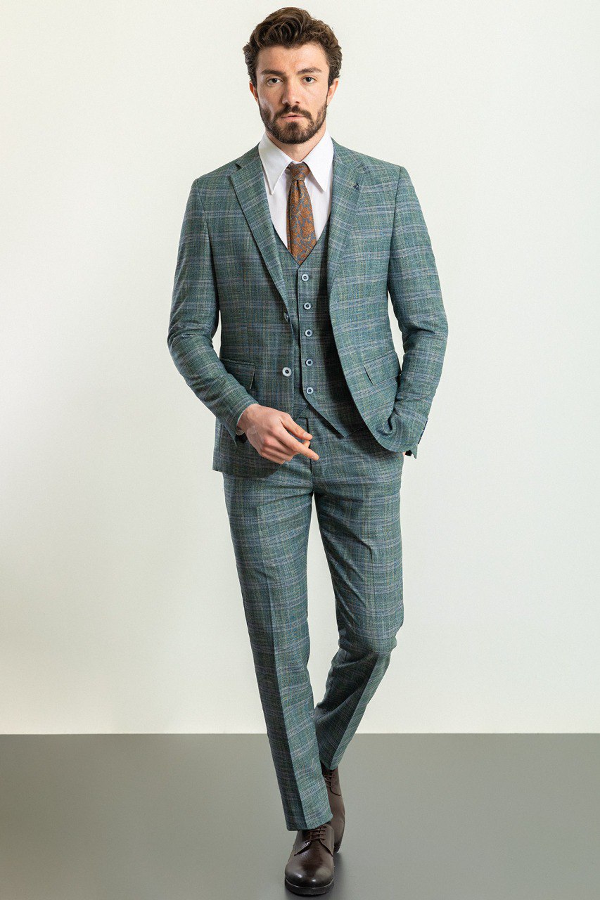 Man wearing an Emerald Plaid 3-Piece Suit with a sharp pointed collar, flap pockets, and a slim fit, perfect for weddings and business engagements.