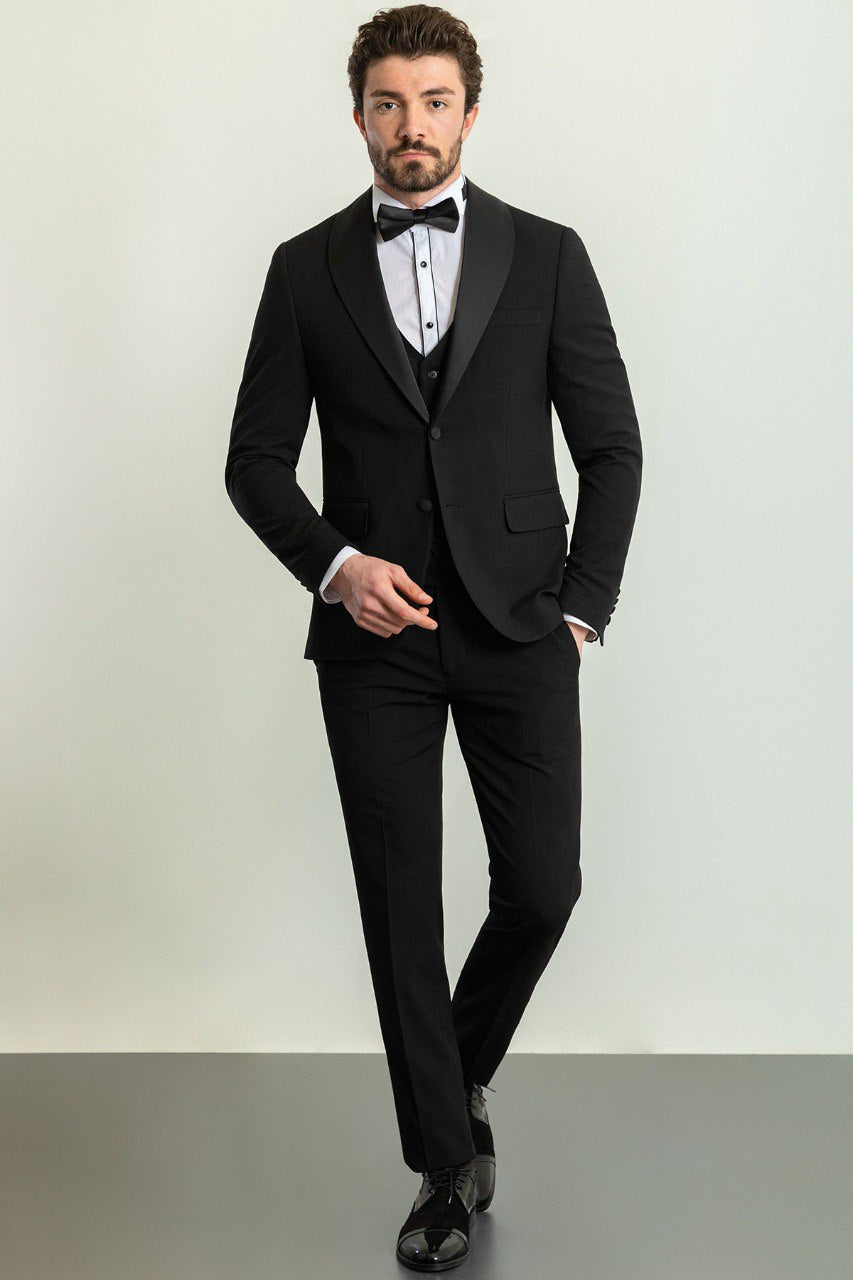 Man wearing a Midnight Velvet Tuxedo with a satin peak lapel, flap pockets, and a slim fit, perfect for black-tie events and weddings.