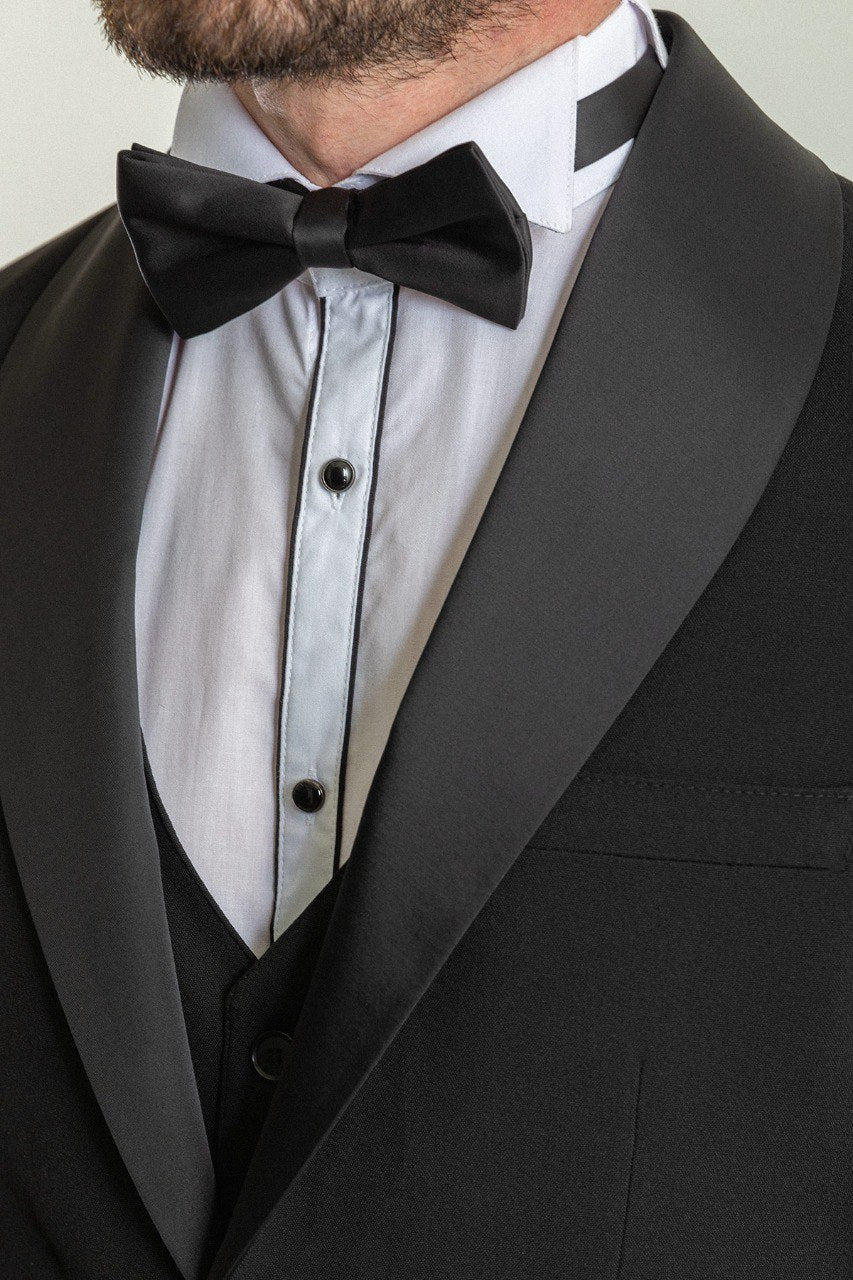 Man wearing a Midnight Velvet Tuxedo with a satin peak lapel, flap pockets, and a slim fit, perfect for black-tie events and weddings.