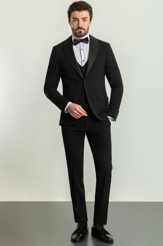 Man wearing a Midnight Velvet Tuxedo with a satin peak lapel, flap pockets, and a slim fit, perfect for black-tie events and weddings.