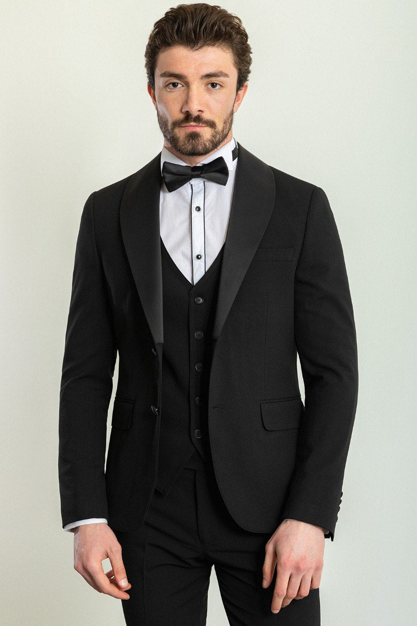 Man wearing a Midnight Velvet Tuxedo with a satin peak lapel, flap pockets, and a slim fit, perfect for black-tie events and weddings.