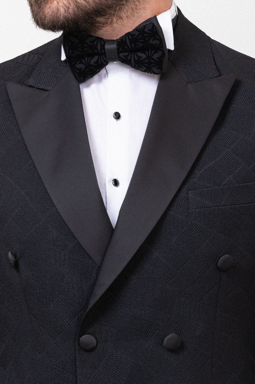 Man in a black double-breasted tuxedo with a bow tie.