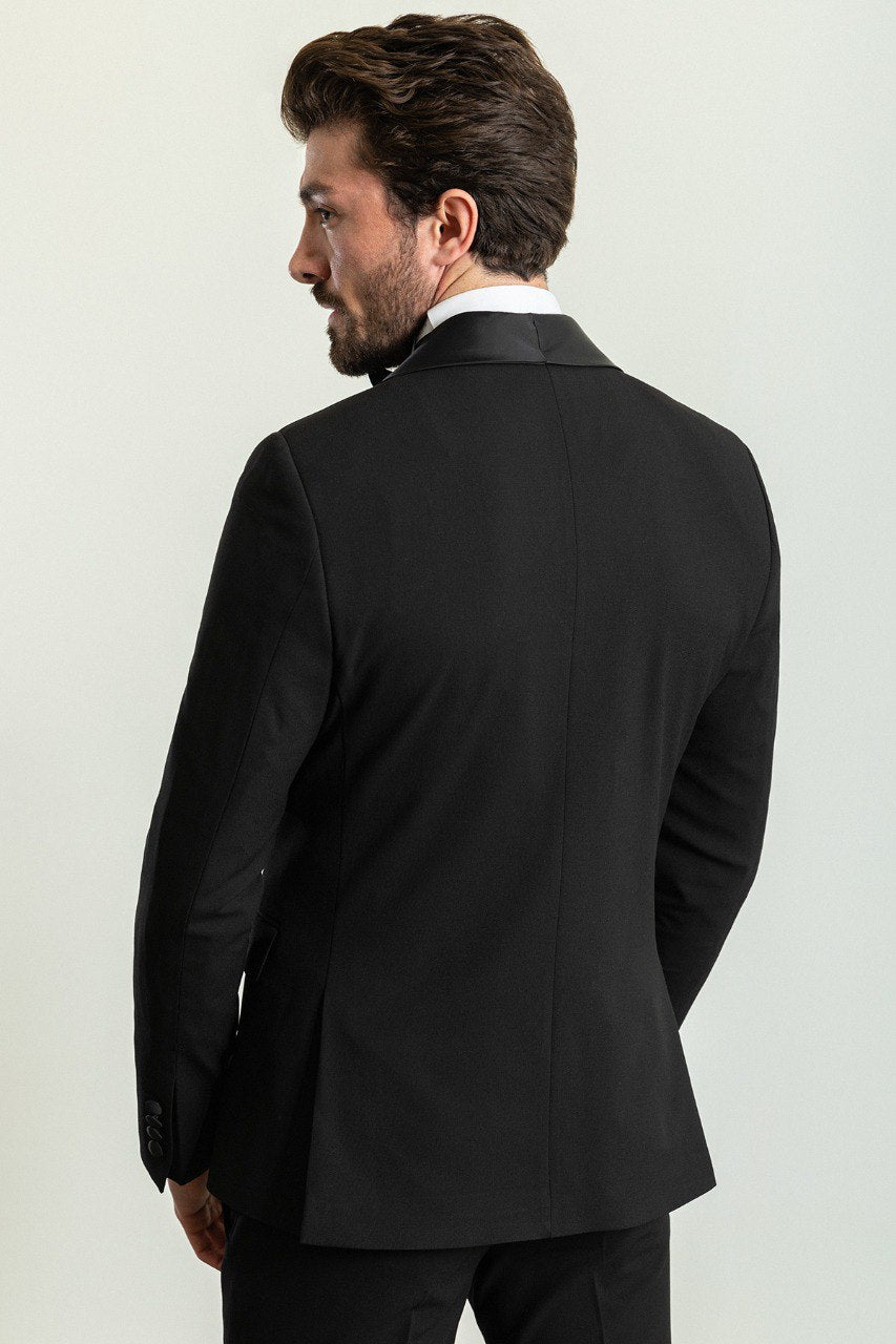 Man wearing a Midnight Velvet Tuxedo with a satin peak lapel, flap pockets, and a slim fit, perfect for black-tie events and weddings.