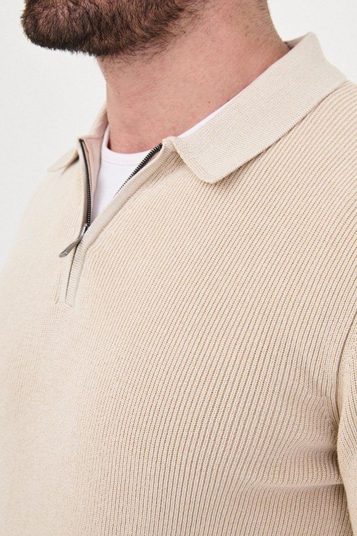 Close-up of the beige sweater's ribbed knit, polo collar and quarter-zip fastening