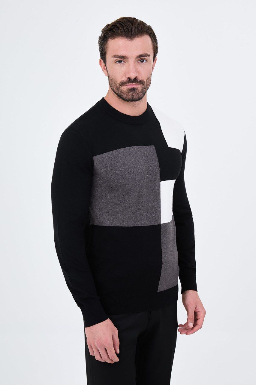 Angled view of a man wearing a black colour-block crew neck sweater