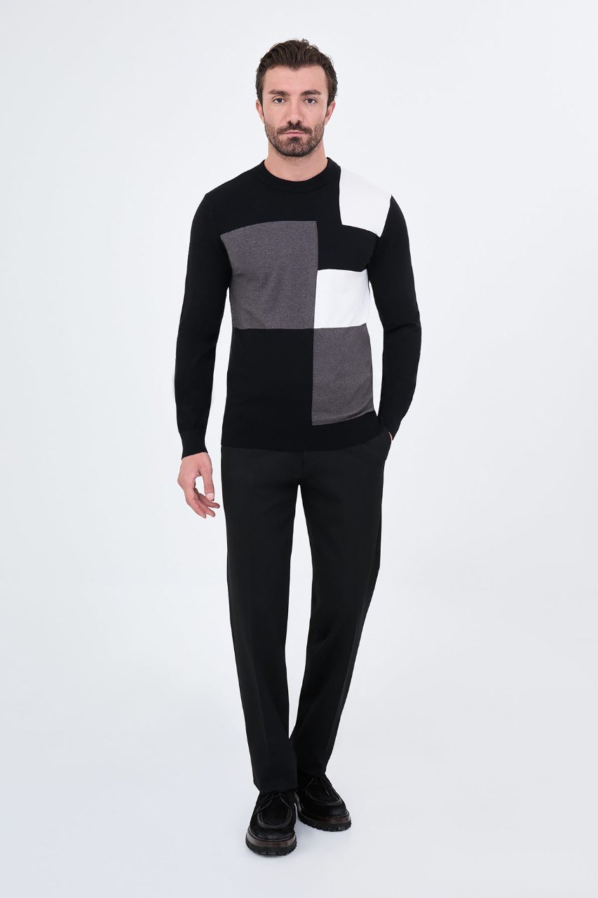 Man wearing a black colour-block sweater with black trousers